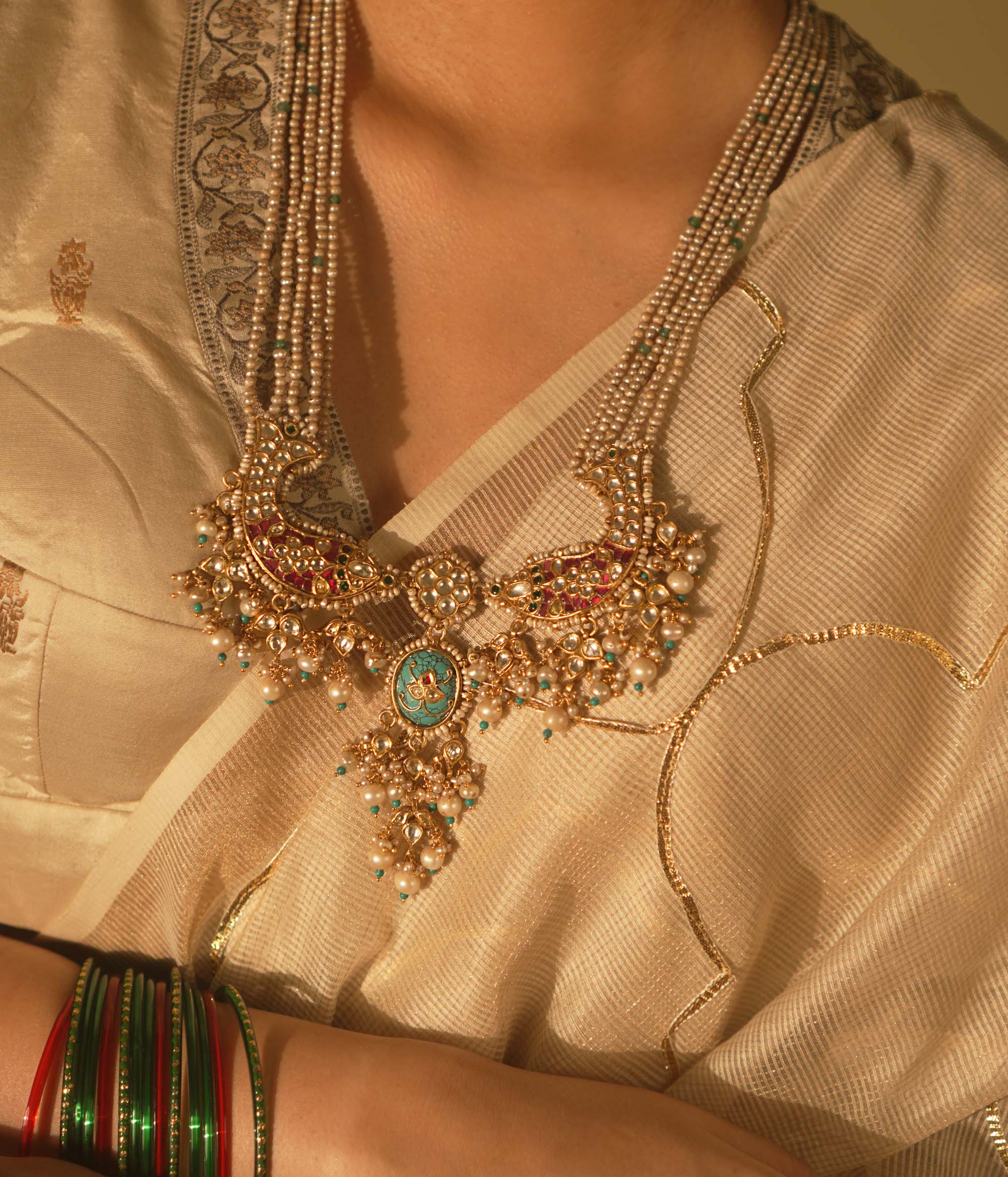 Gold-veiled silver necklace with abstract fish motifs, pearls, and Kundan stones—blending heritage, ocean lore, and artistry.