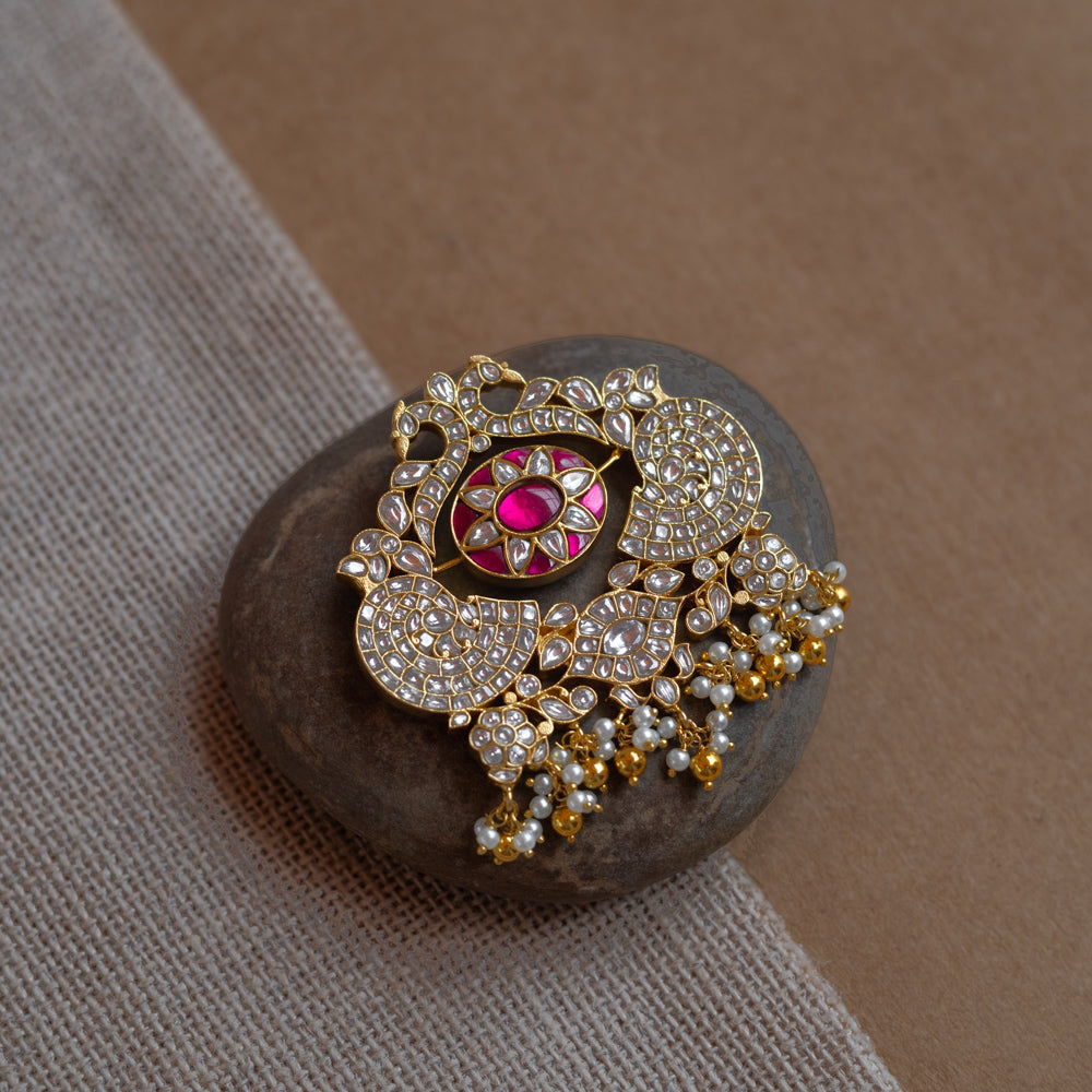 Dual-sided kundan pendant with red and green stones, pearl danglers, and peacock motif design.