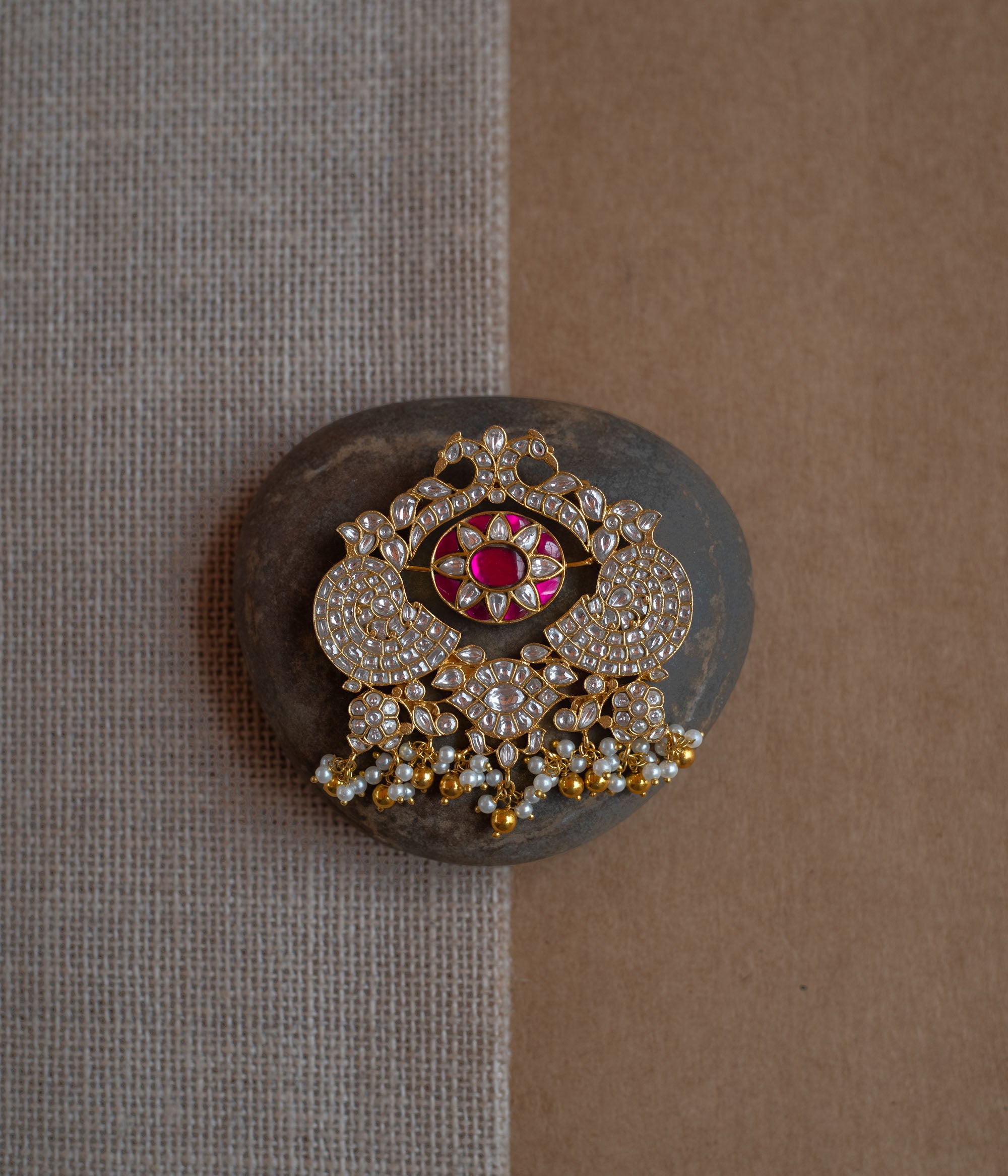 Dual-sided kundan pendant with red and green stones, pearl danglers, and peacock motif design.