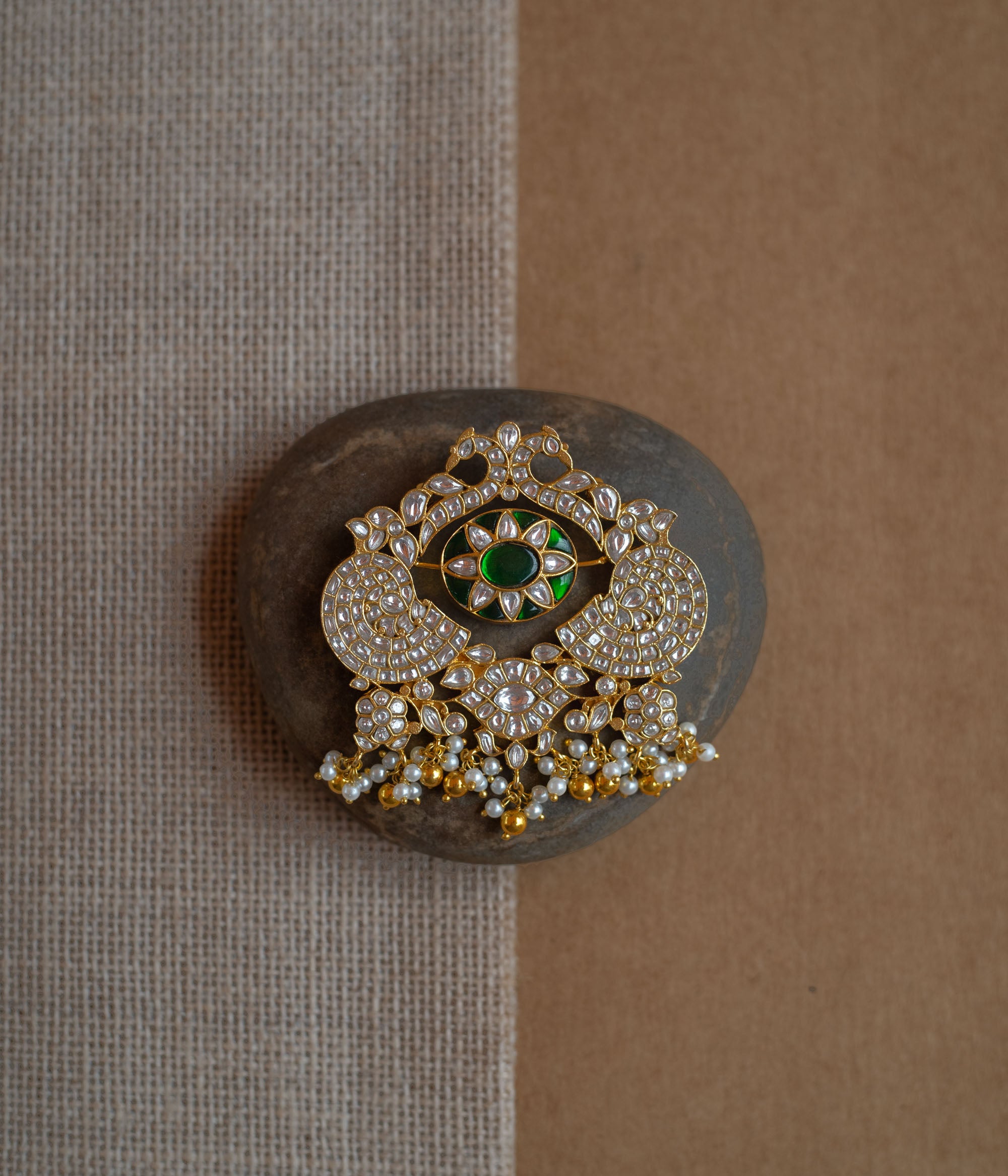 Dual-sided kundan pendant with red and green stones, pearl danglers, and peacock motif design.