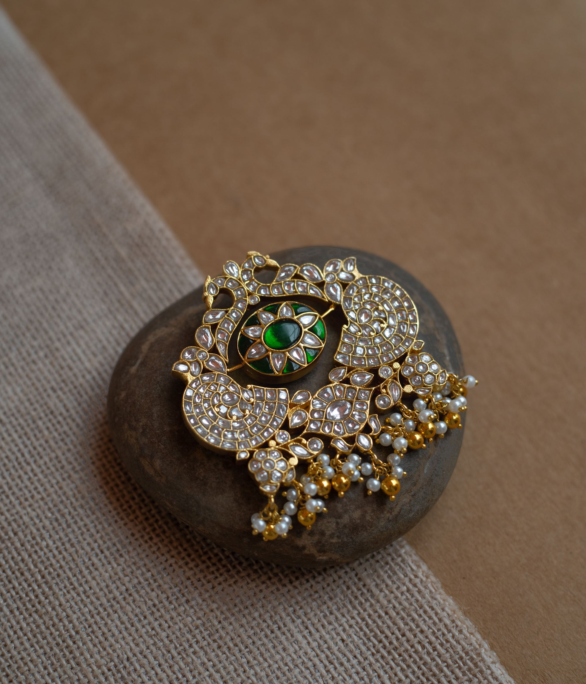 Dual-sided kundan pendant with red and green stones, pearl danglers, and peacock motif design.