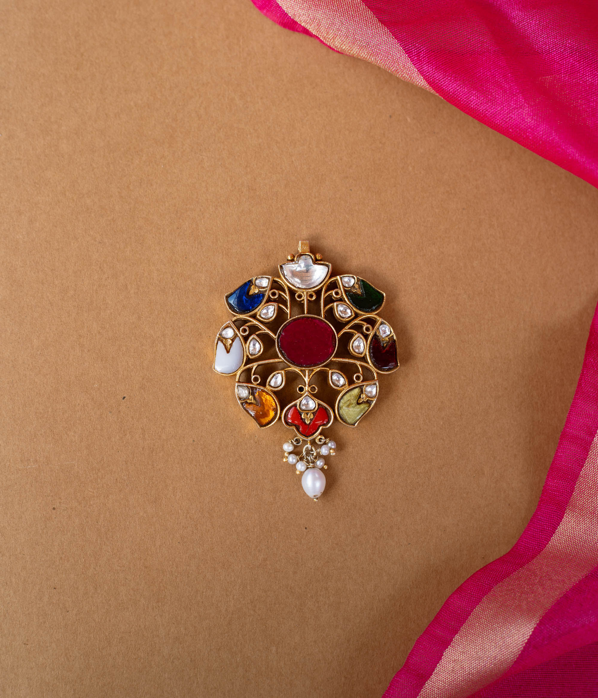 A round Kundan pendant with a central stone and dangling pearl drops.