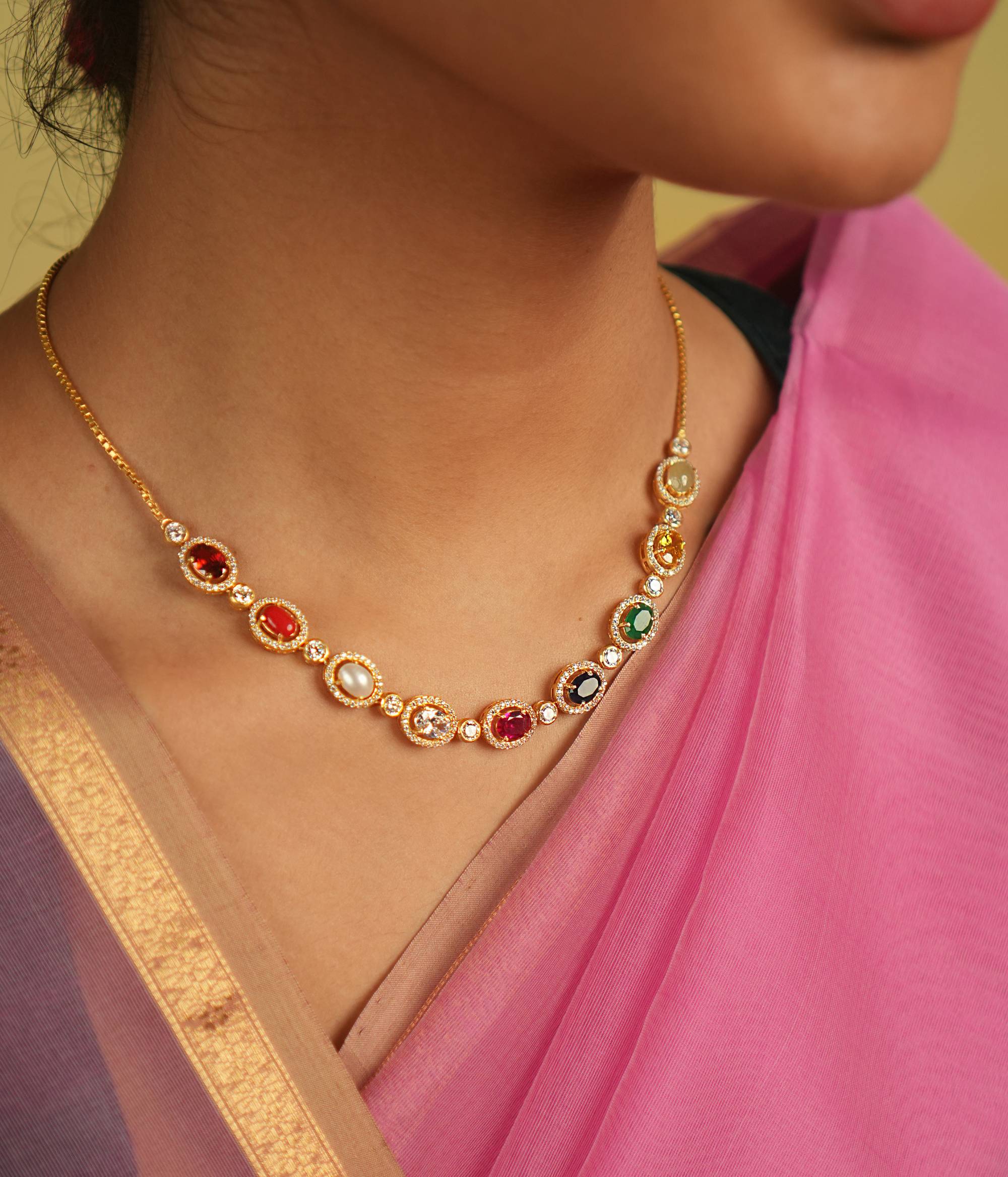 A sleek Navaratna necklace, adorned with shimmering Moissanites, radiates celestial grace and timeless charm.