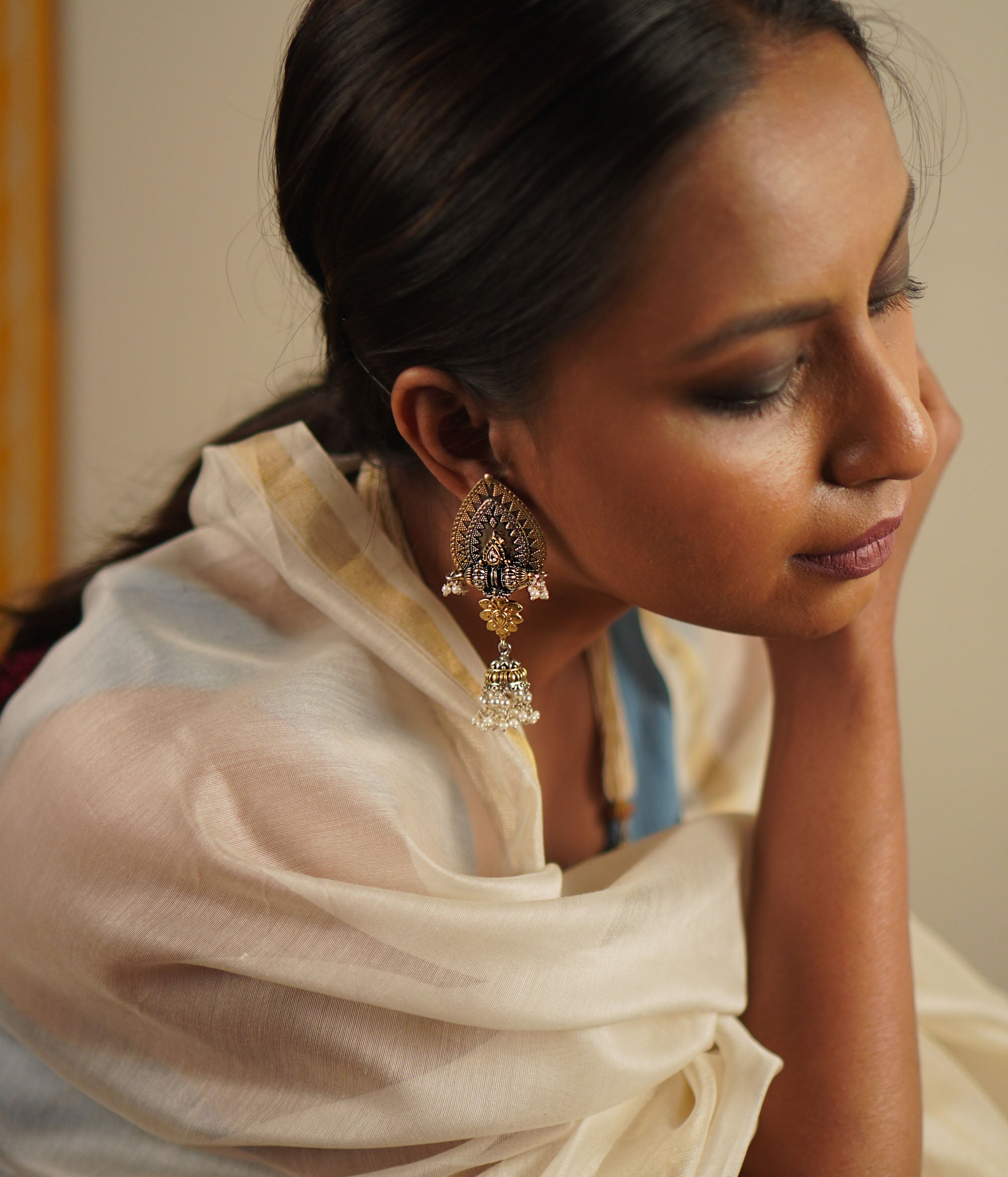 The Kavel earrings, fashioned in oxidized silver with luminous pearls and white kundan, beautifully merge classic craftsmanship with contemporary charm.