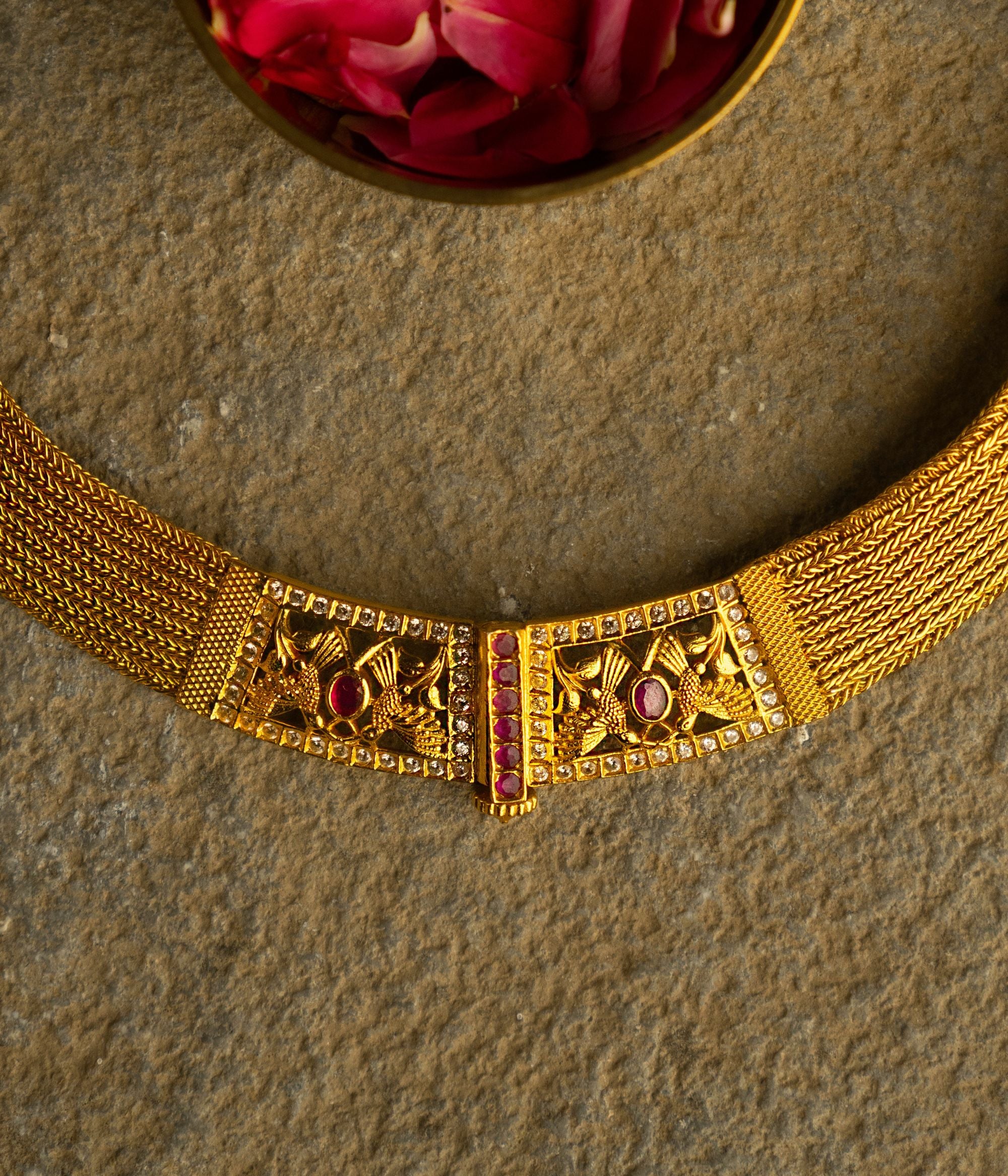 Elegant gold-plated silver necklace featuring a continuous flat-structured chain with a secure screw closure at the end. The design is adorned with intricate tiny peacock motifs, embellished with vibrant red Kundan stones and shimmering CZ stones, adding a touch of traditional grace and sophistication.