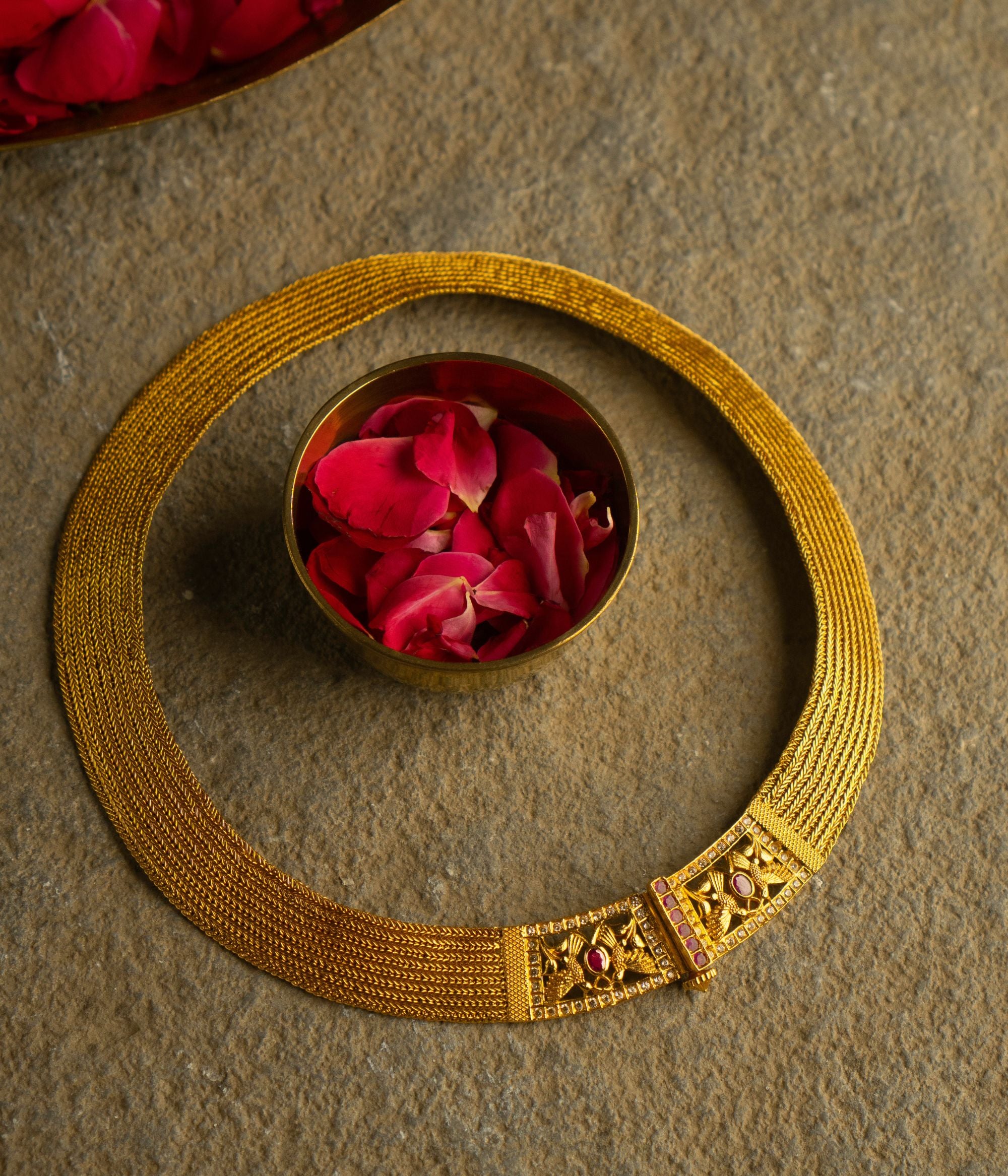 Elegant gold-plated silver necklace featuring a continuous flat-structured chain with a secure screw closure at the end. The design is adorned with intricate tiny peacock motifs, embellished with vibrant red Kundan stones and shimmering CZ stones, adding a touch of traditional grace and sophistication.