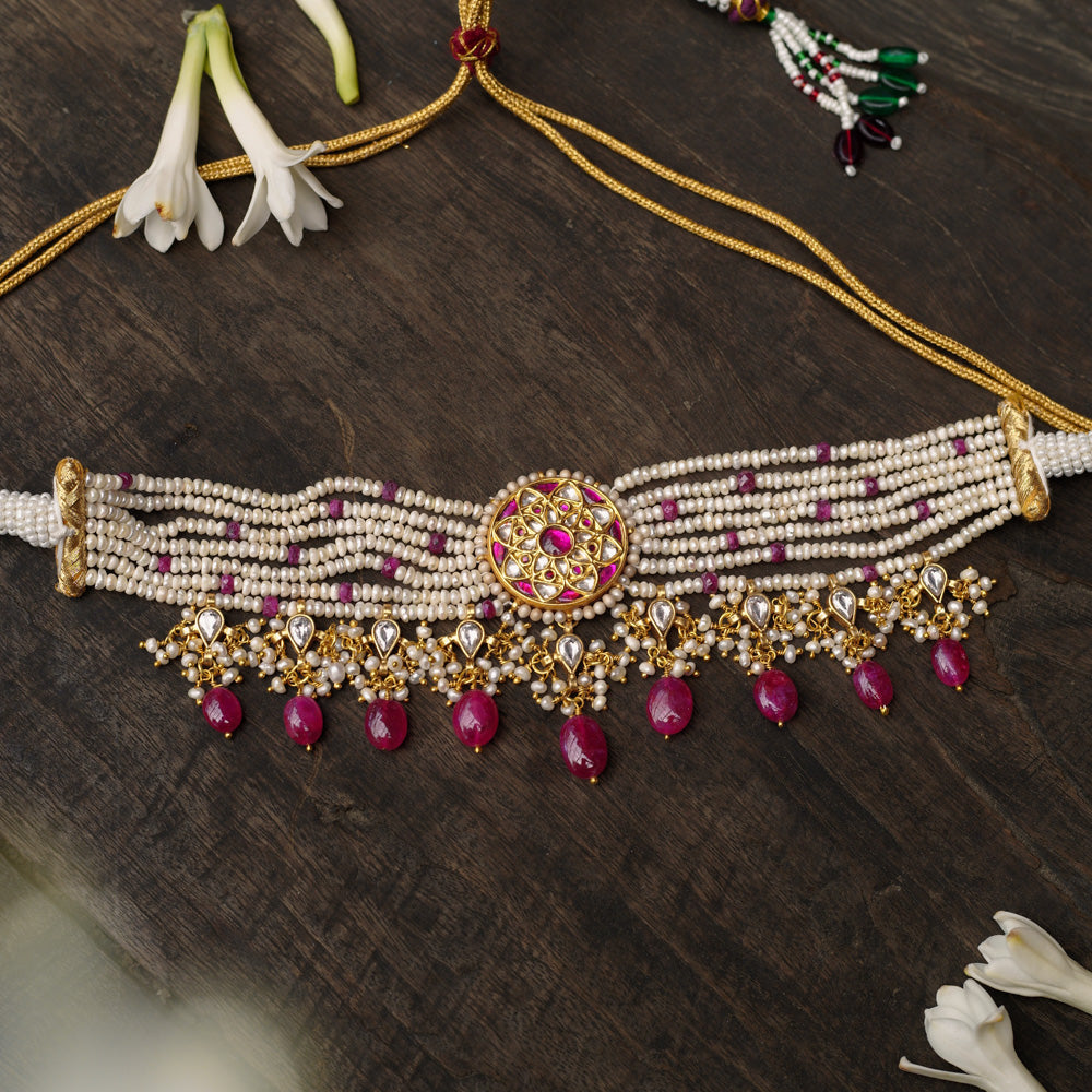 Gold choker with ruby medallion, pearl strands, white sapphires, and ruby drops from Leelah Collection.