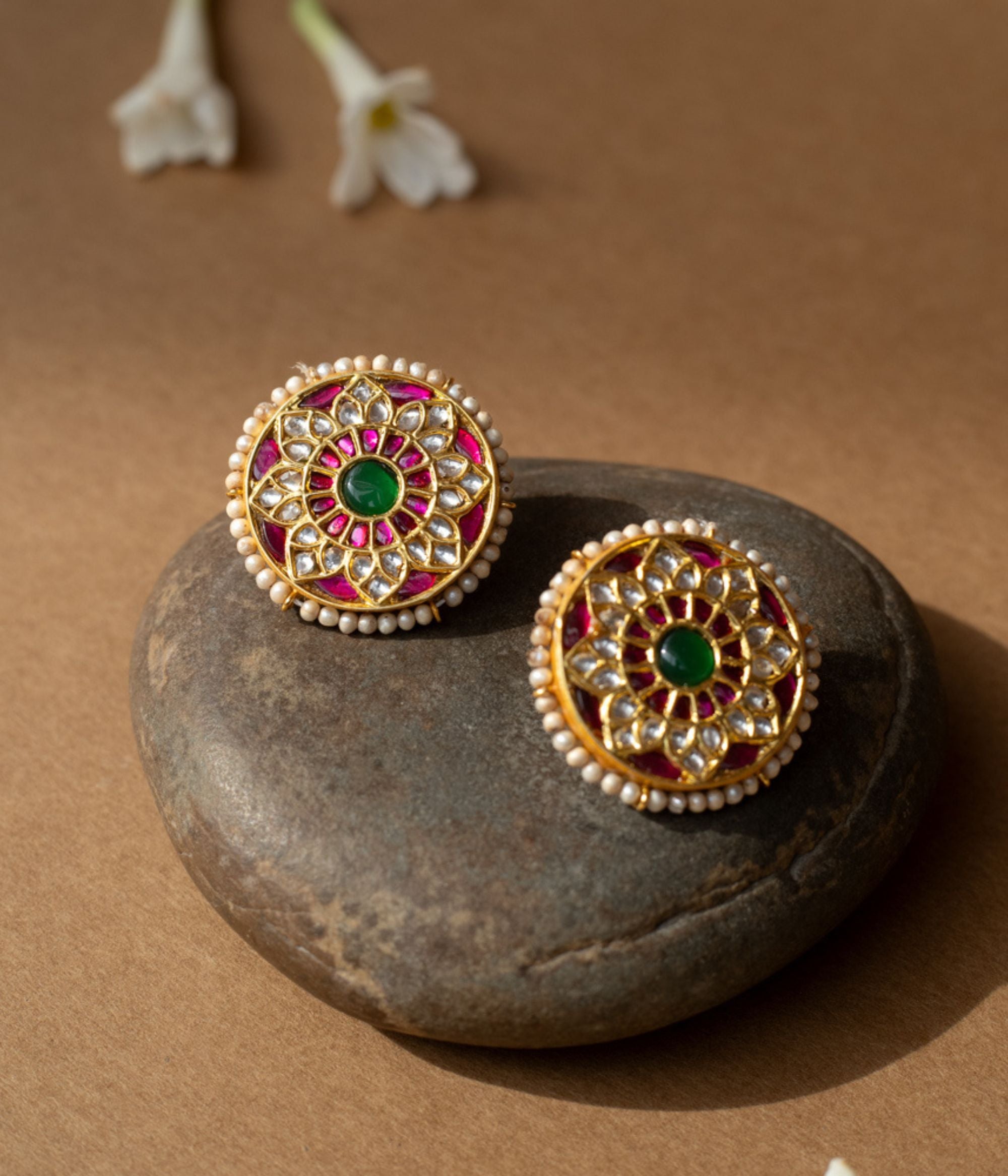 Round lotus-shaped earrings with rubies, white sapphires, pearl border, and green center from Leelah collection.