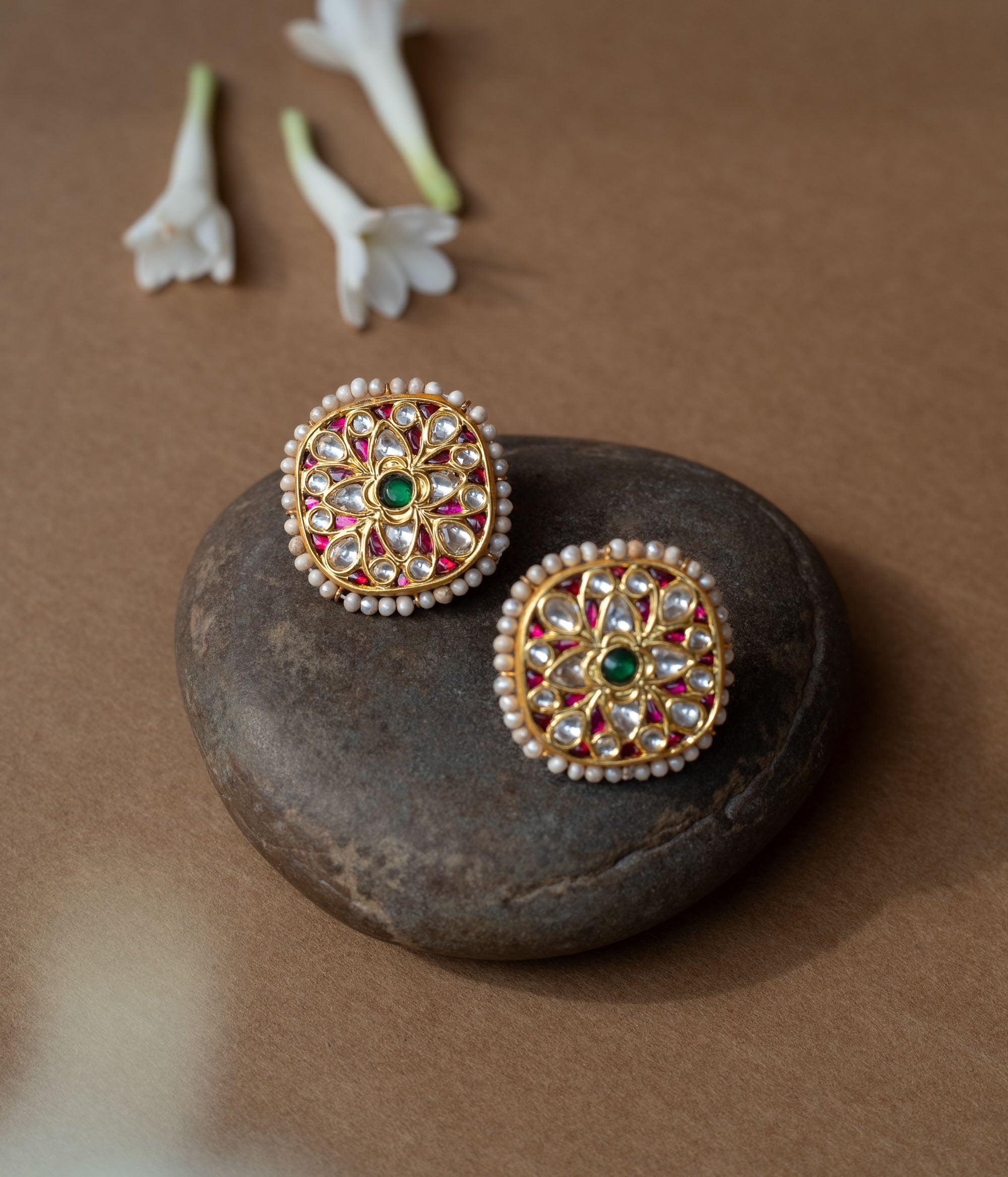 Square gold earrings with ruby, white sapphire petal motifs and a green center from Leelah collection.