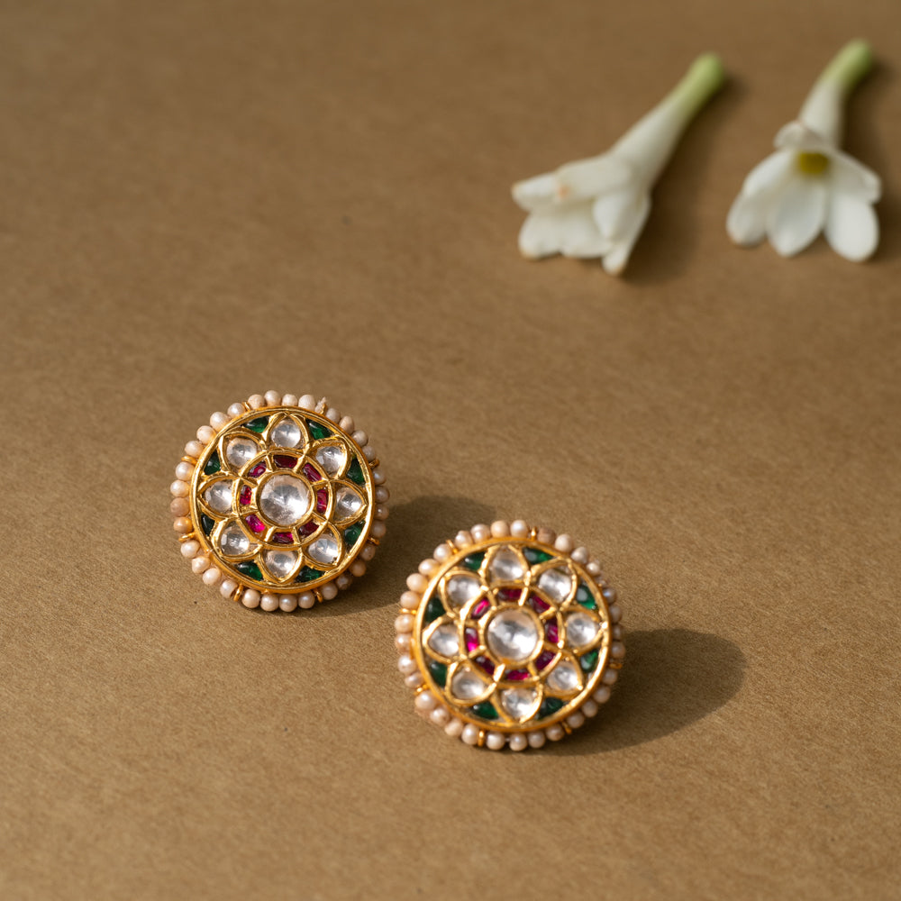 Round lotus-style earrings with white sapphires, rubies, green enamel accents, and pearl border.