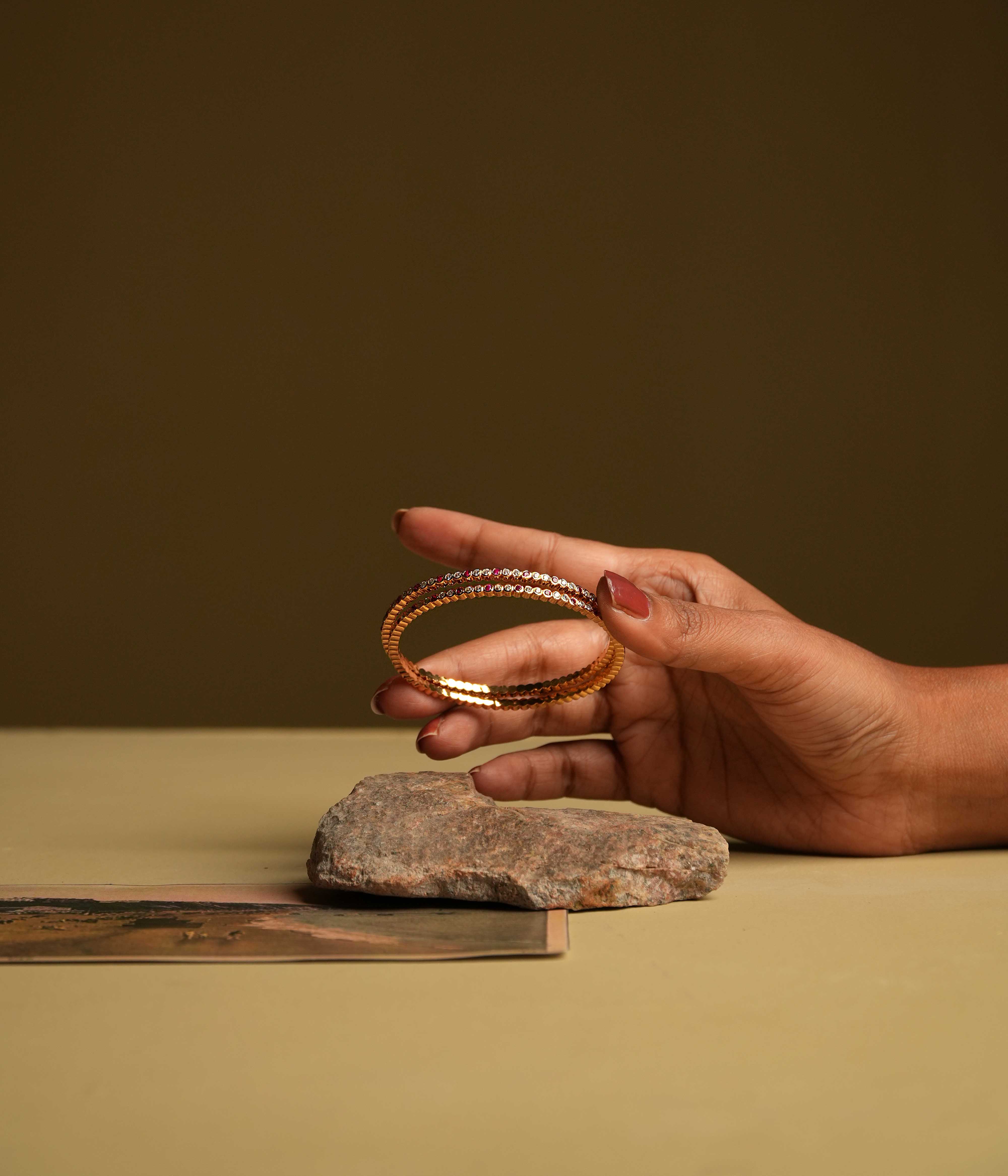 A delicate 92.5 sterling silver bangle featuring moissanite and red gemstones in a single line, inspired by classic Chettinad stone settings and exuding understated luxury.