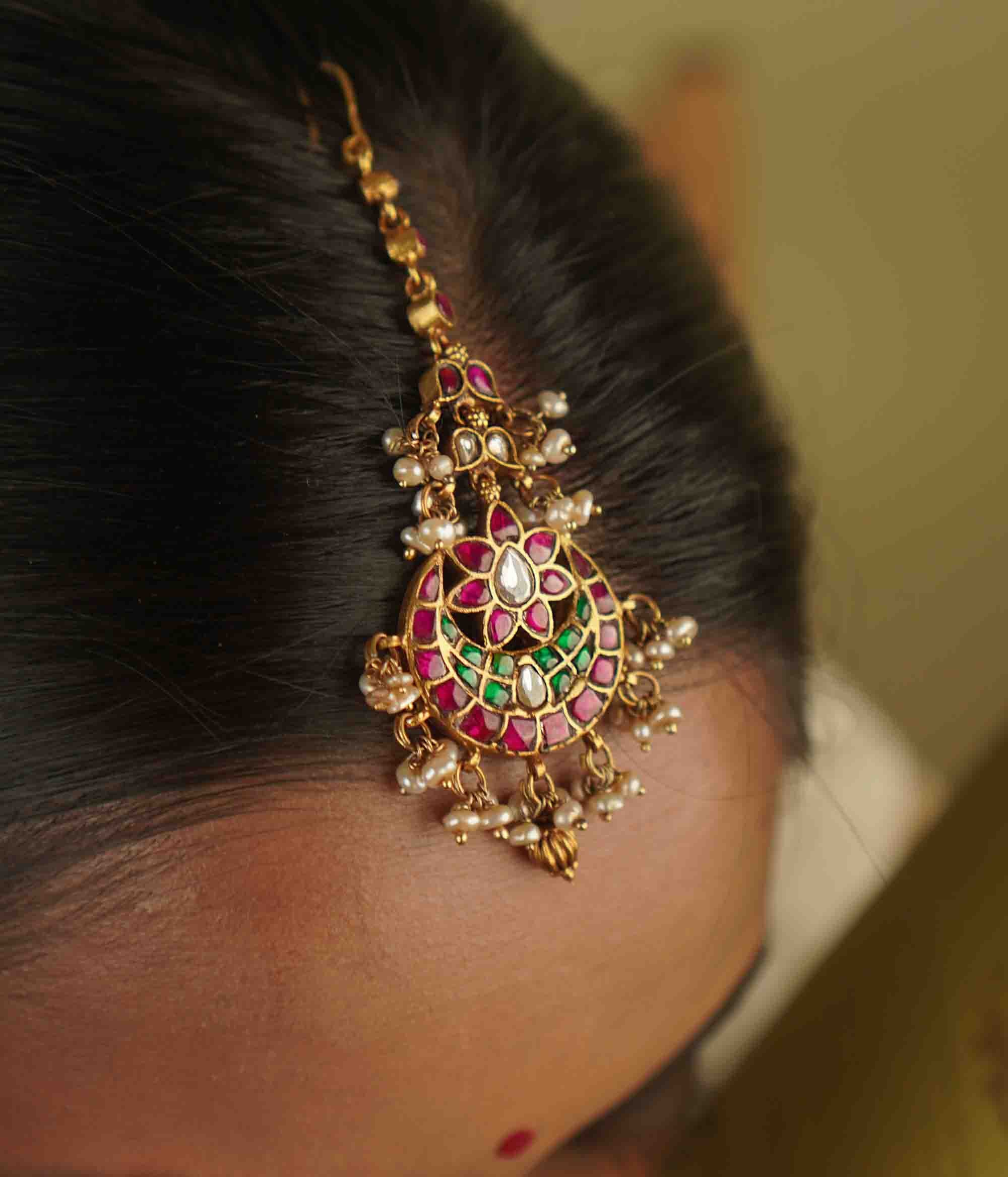 Lalika Maangtika: A celestial masterpiece. Crafted in gold-plated silver with kundans and pearls, this tikka captures the mystique of the night sky. A timeless treasure, elegantly reimagined.