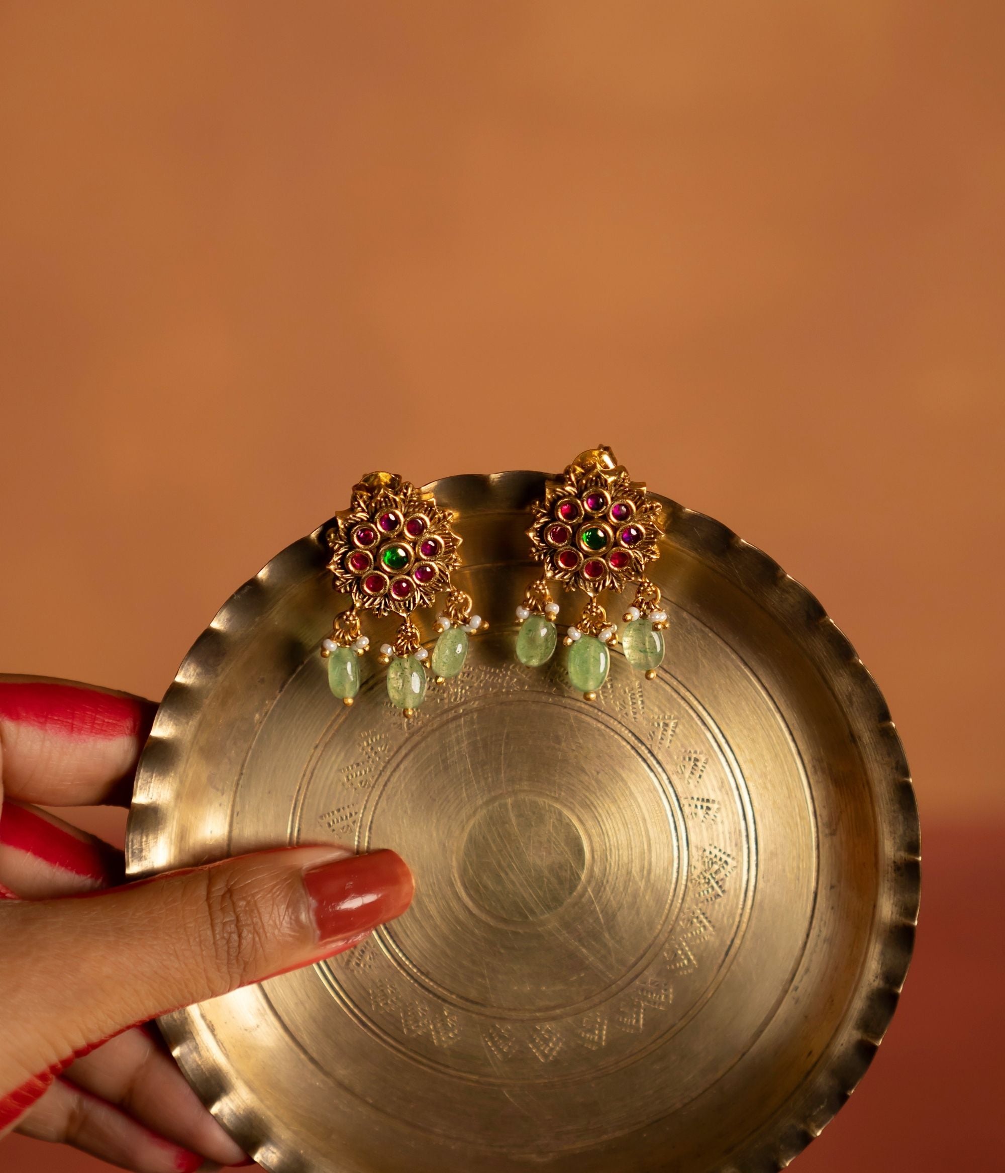 Exquisite gold-plated silver drop earrings in a stunning round shape, adorned with vibrant red and green spinel stones. The elegant design is further enhanced by delicate drops of green strawberry quartz, adding a graceful and sophisticated touch. A perfect blend of timeless charm and modern elegance.