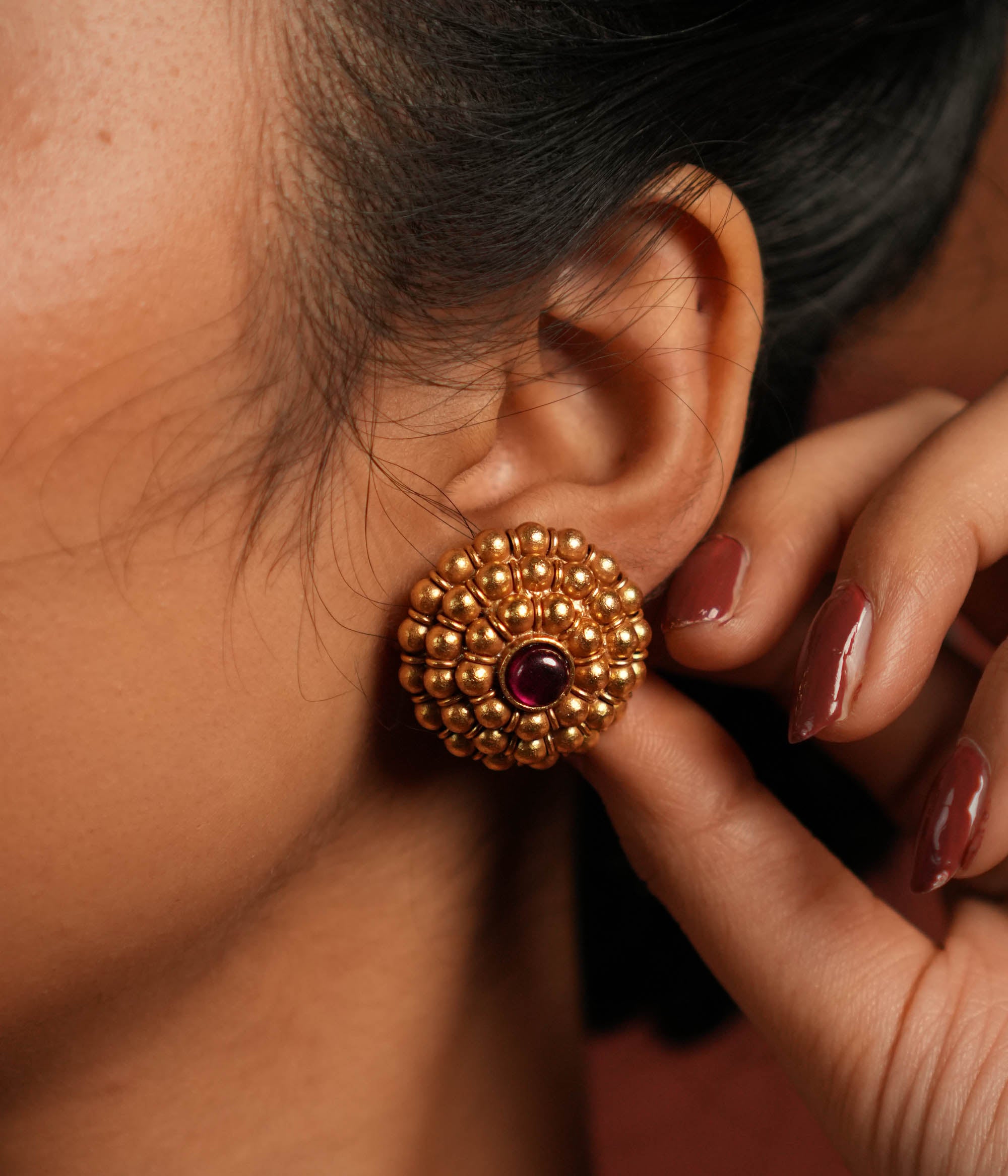These gold-plated silver stud earrings showcase dainty coin-like motifs arranged in a graceful circular pattern. Inspired by vintage Kolhapuri tribal designs, they blend tradition with elegance, making them a timeless addition to any jewelry collection.