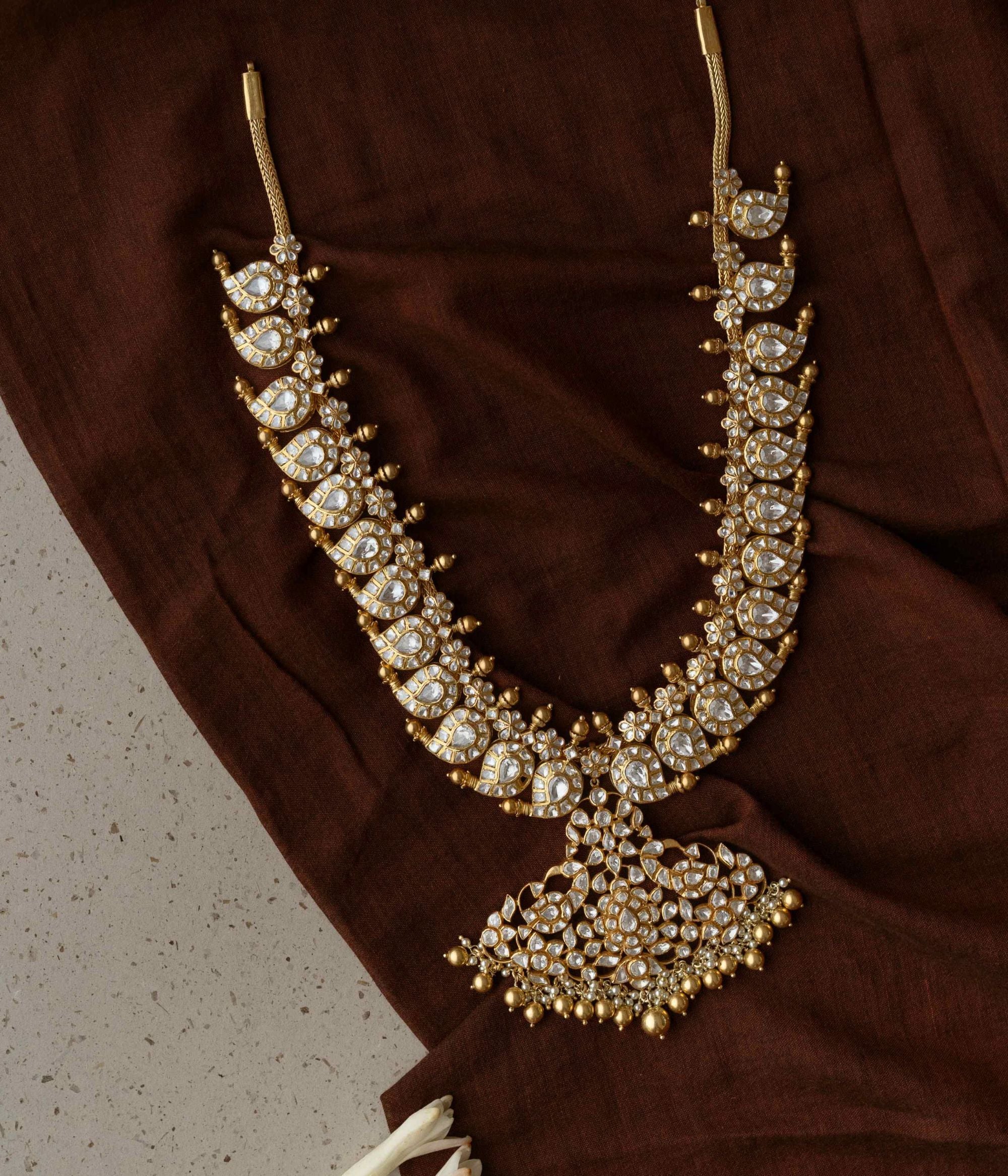 A necklace of enchantment, Woven with Polki Stones , it crowns its wearer in regal splendor.
