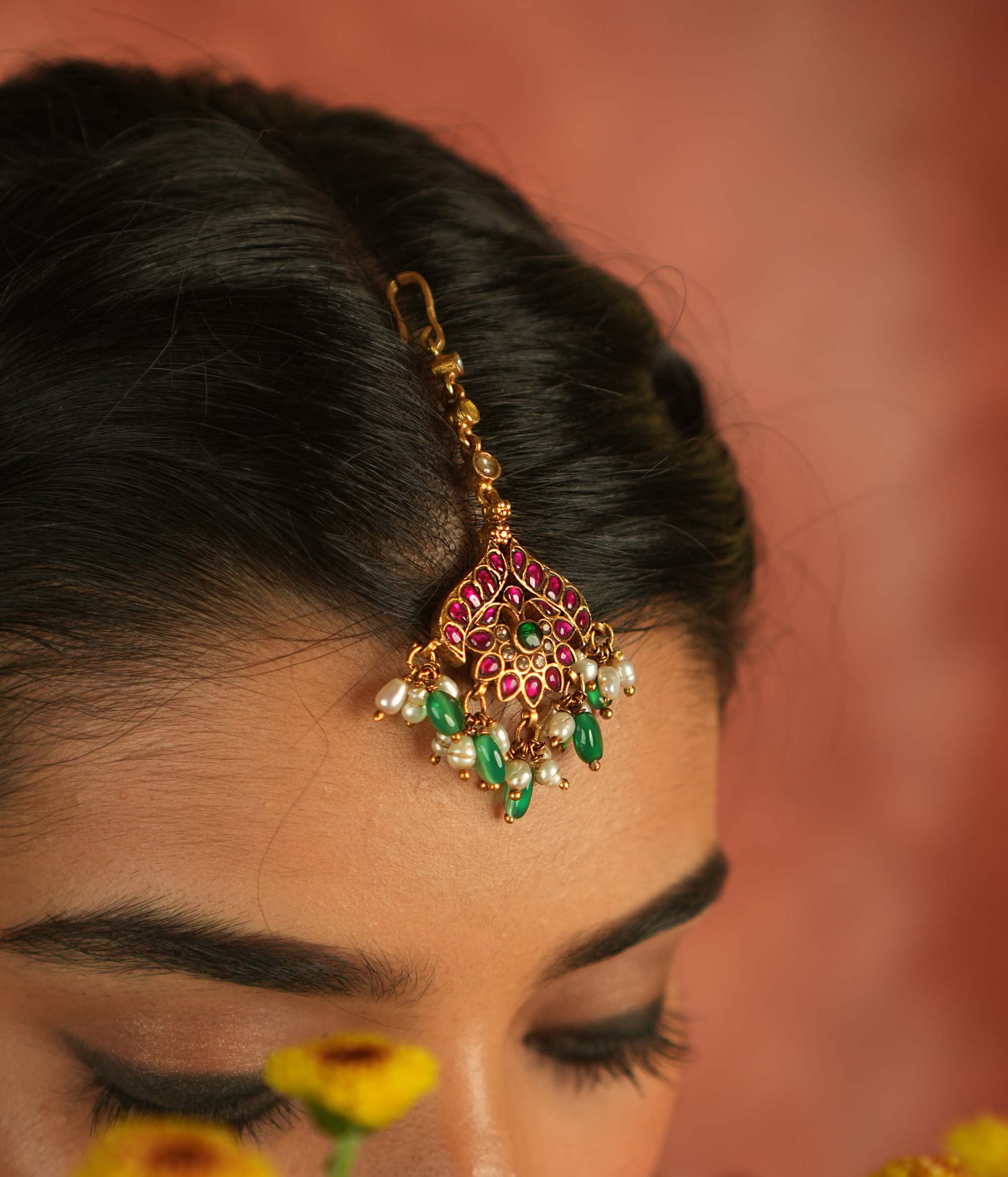 Bridal blossom! Red, white, and green lotus maangtika: A symbol of grace and renewal, radiating timeless elegance.