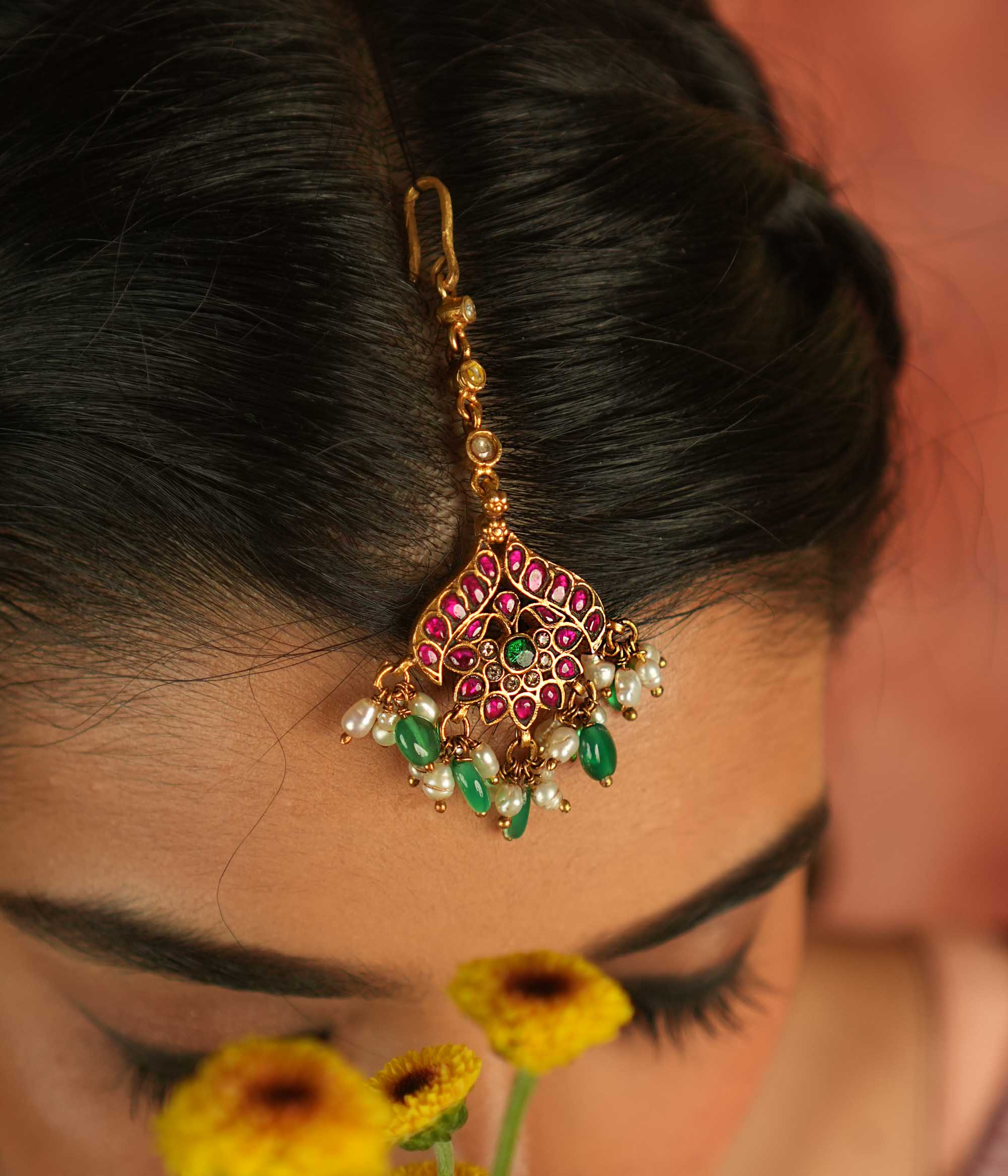 Bridal blossom! Red, white, and green lotus maangtika: A symbol of grace and renewal, radiating timeless elegance.