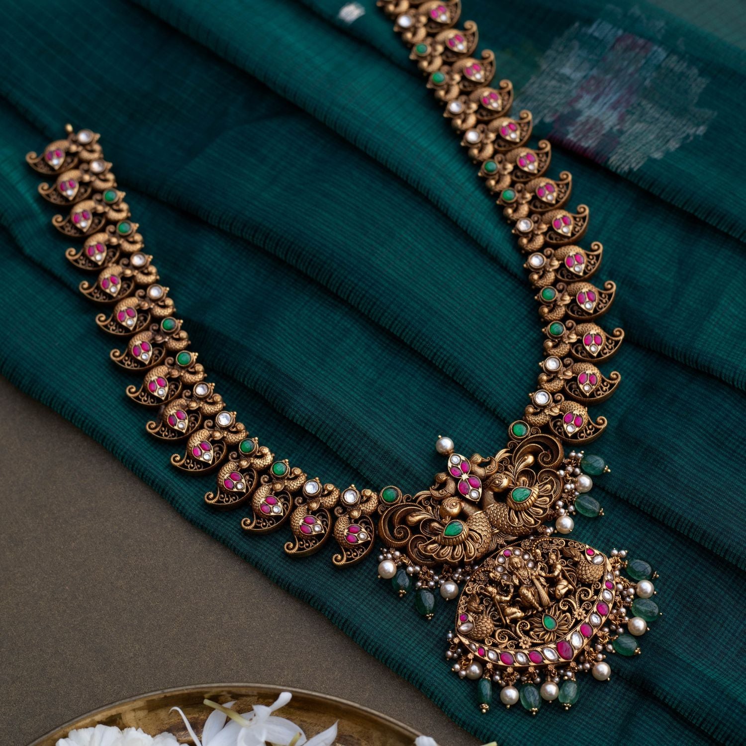 Embrace Timeless Elegance with Intricate Artistry With Kundan stones and green beads with temple inspired design
