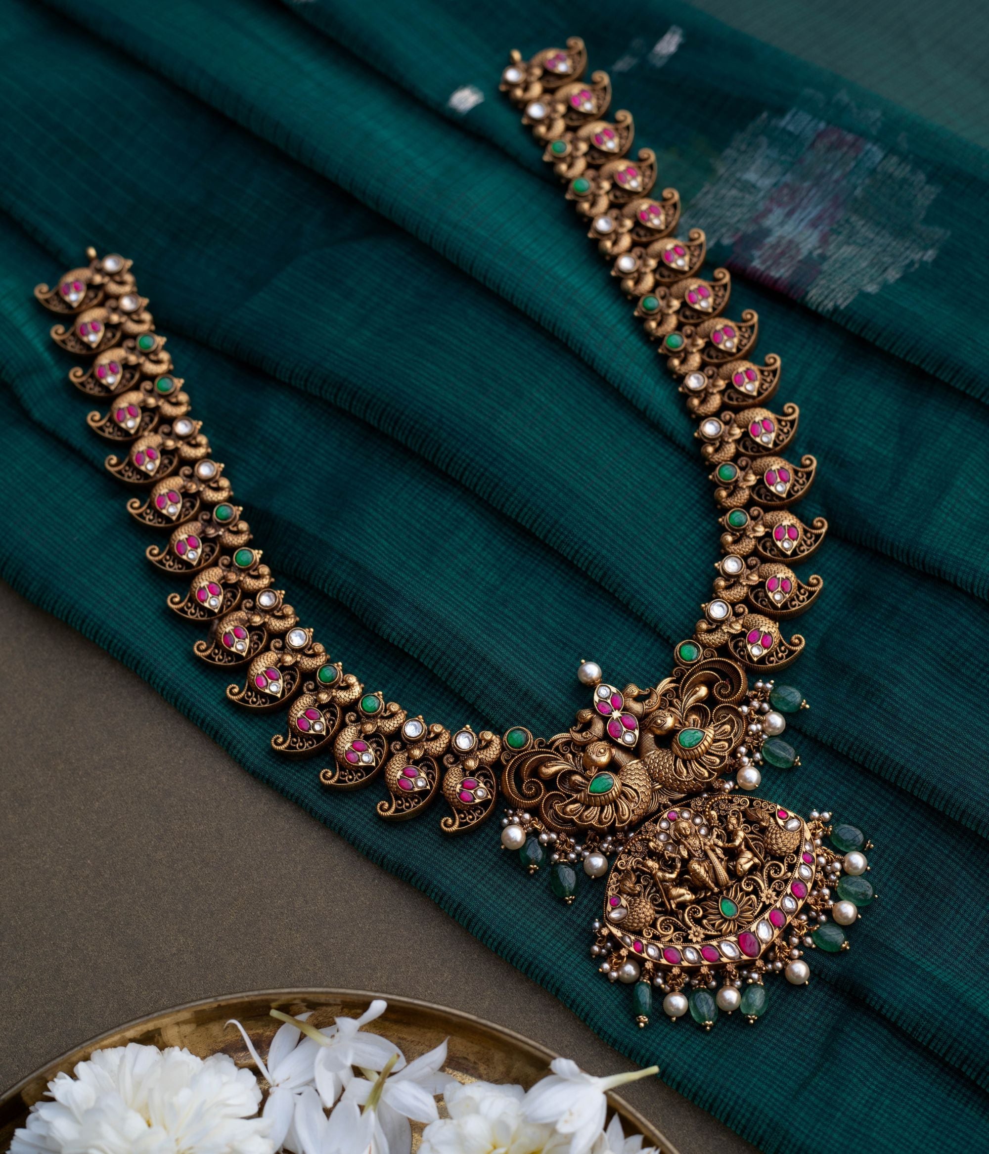 Embrace Timeless Elegance with Intricate Artistry With Kundan stones and green beads with temple inspired design