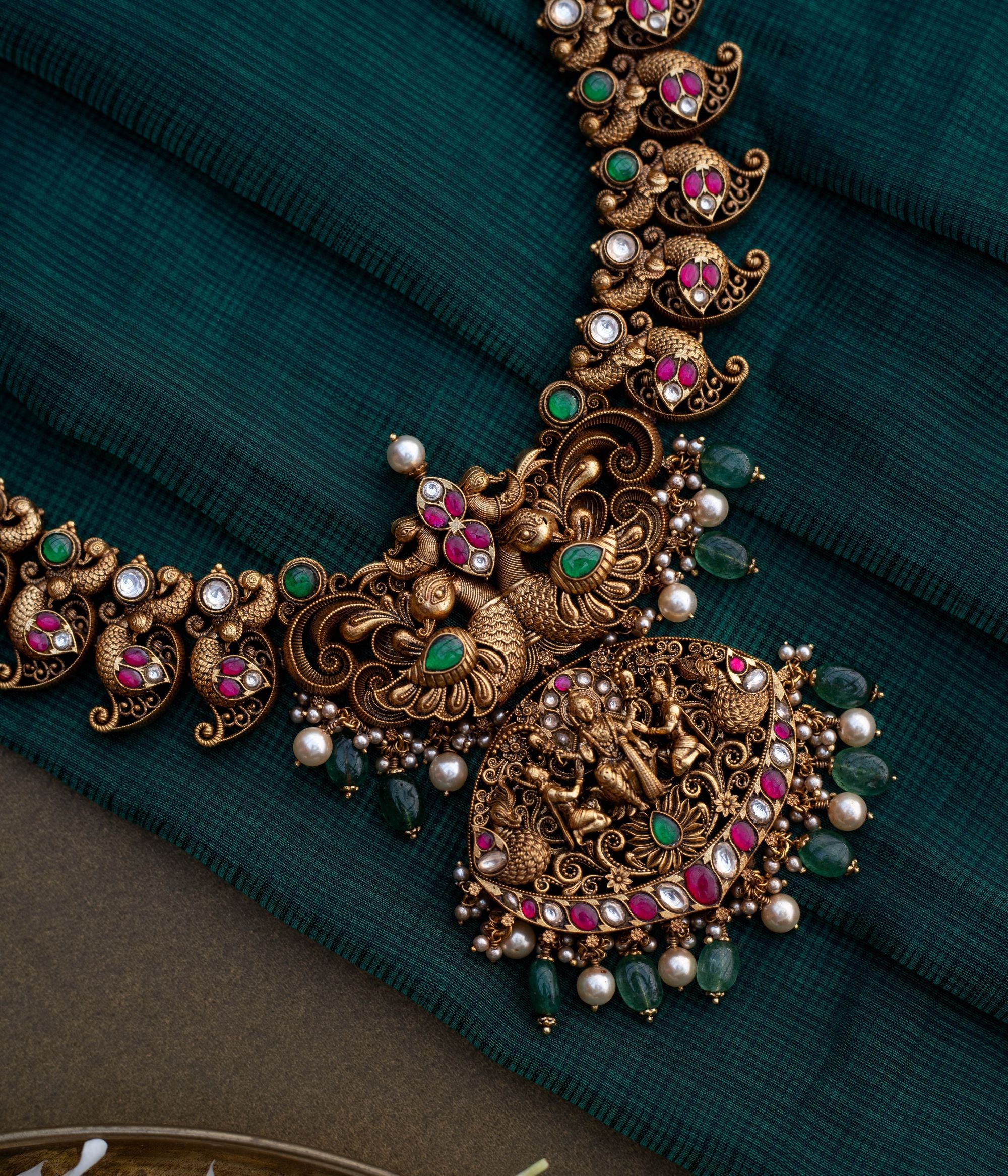 Embrace Timeless Elegance with Intricate Artistry With Kundan stones and green beads with temple inspired design