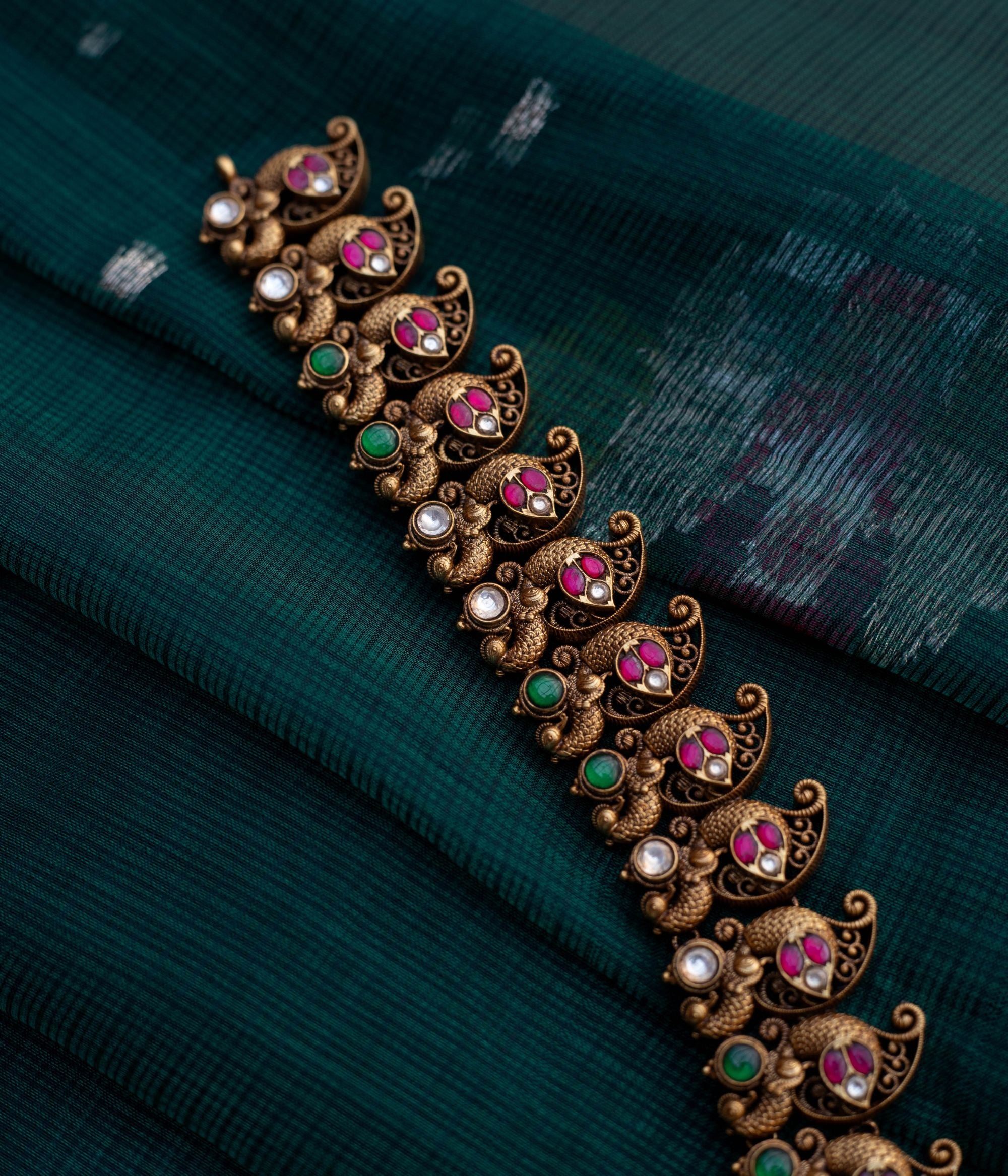 Embrace Timeless Elegance with Intricate Artistry With Kundan stones and green beads with temple inspired design
