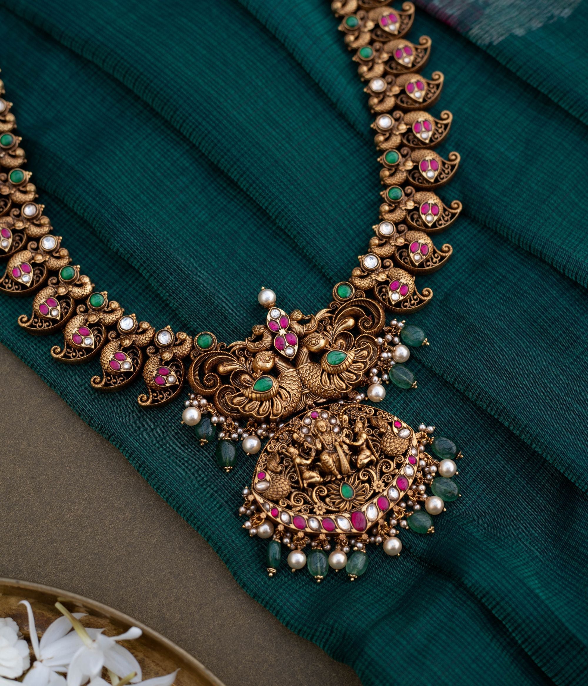 Embrace Timeless Elegance with Intricate Artistry With Kundan stones and green beads with temple inspired design