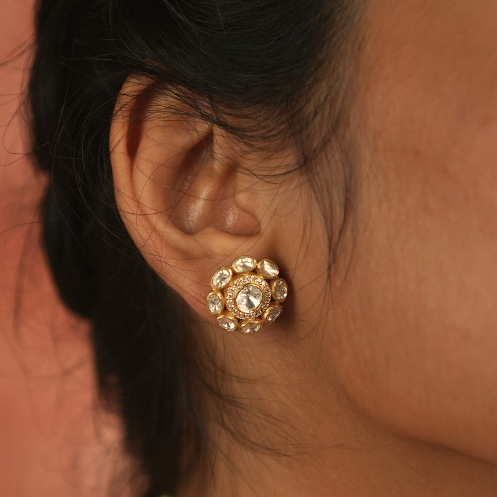 Artistry redefined! These round polki stud earrings, set in gold-plated silver, shimmer with moissanite brilliance, capturing nature's timeless charm.