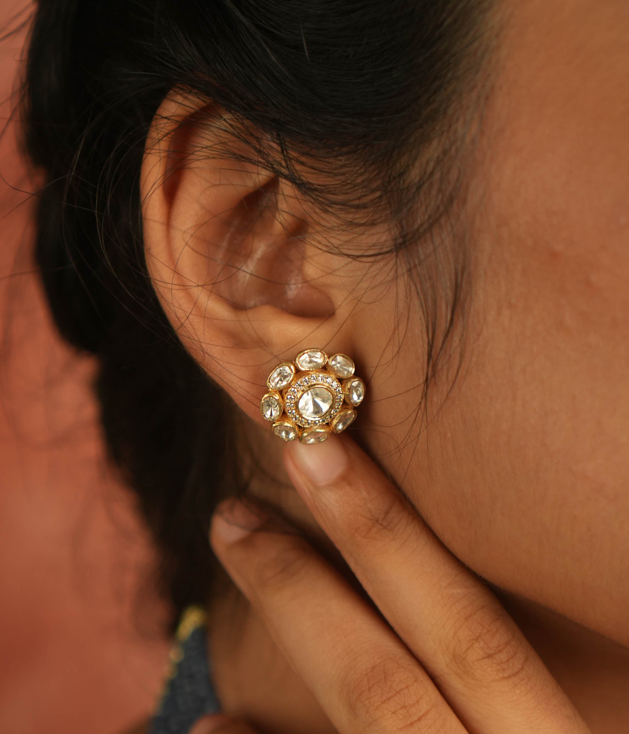 Artistry redefined! These round polki stud earrings, set in gold-plated silver, shimmer with moissanite brilliance, capturing nature's timeless charm.