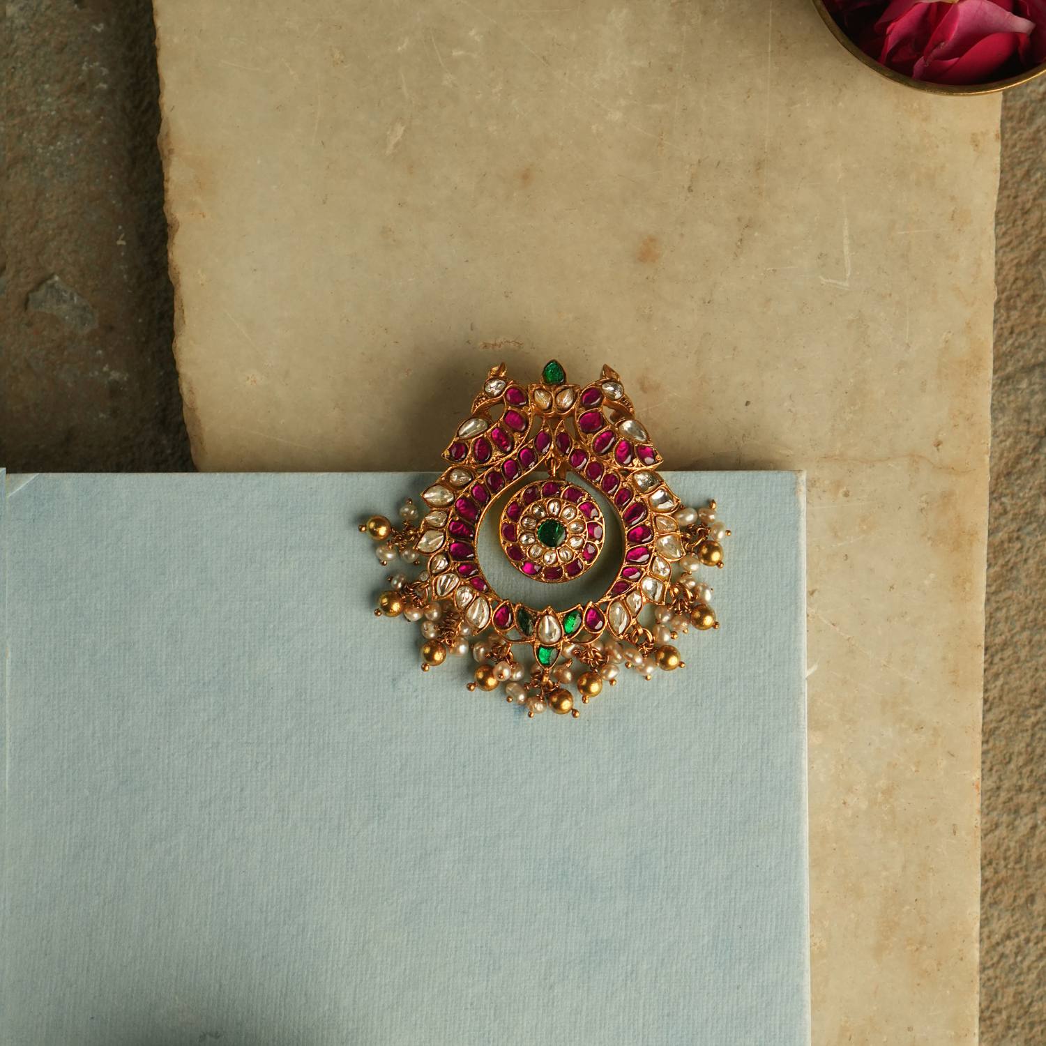 The Nehark Pendant exudes timeless allure, adorned with red, white, and green Kundan stones along with golden beads. A radiant masterpiece, it echoes the mystique of ancient traditions, captivating the soul with its enchanting glow.