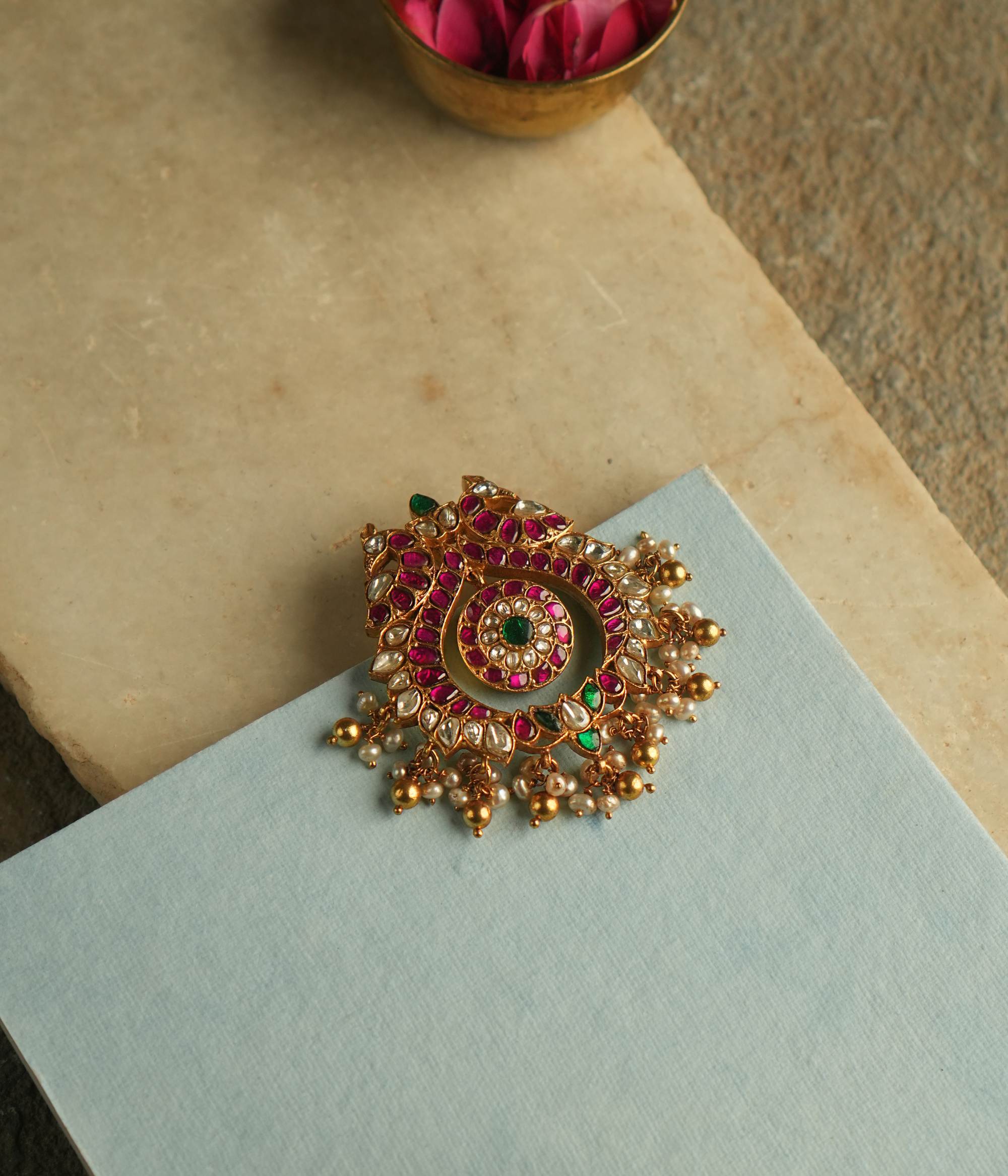 The Nehark Pendant exudes timeless allure, adorned with red, white, and green Kundan stones along with golden beads. A radiant masterpiece, it echoes the mystique of ancient traditions, captivating the soul with its enchanting glow.