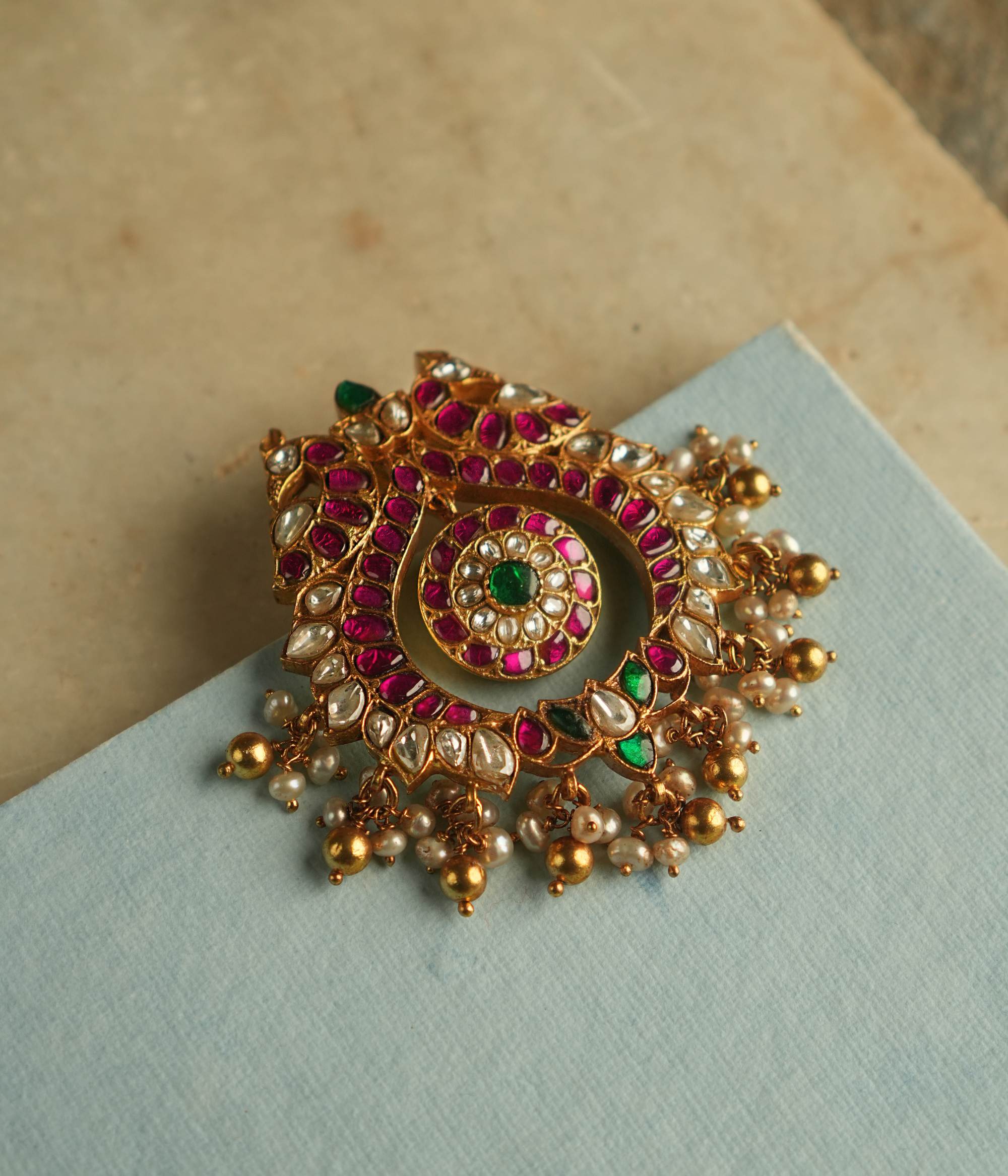The Nehark Pendant exudes timeless allure, adorned with red, white, and green Kundan stones along with golden beads. A radiant masterpiece, it echoes the mystique of ancient traditions, captivating the soul with its enchanting glow.