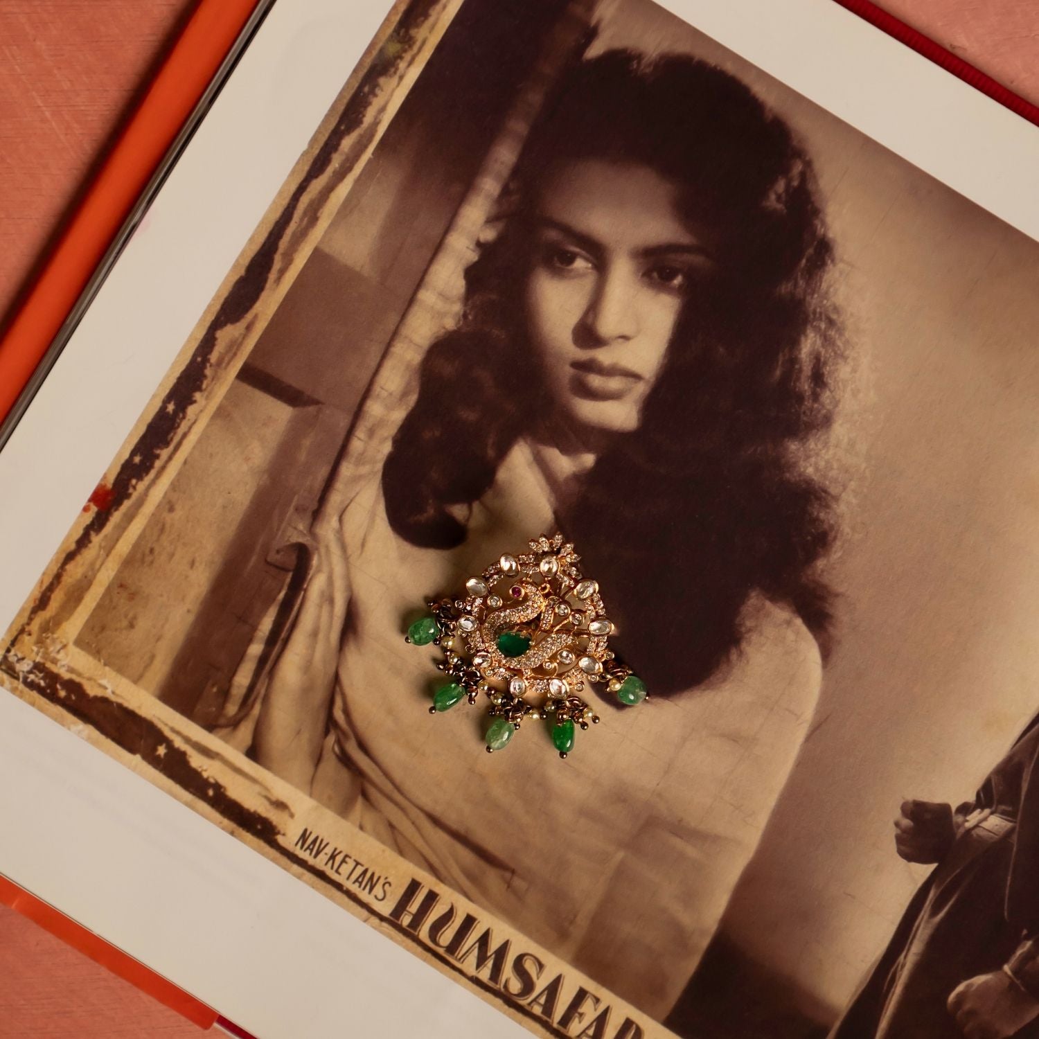 A mesmerizing gold-plated silver pendant featuring a majestic peacock at its center, intricately crafted with CZ stones and vibrant red cz stones. Encircling the peacock is a delicate arrangement of shimmering Polki stones, enhancing its regal allure. The pendant is further adorned with cascading drops of lush green strawberry quartz, adding a touch of elegance and charm. A perfect blend of tradition and craftsmanship, this pendant exudes timeless beauty.
