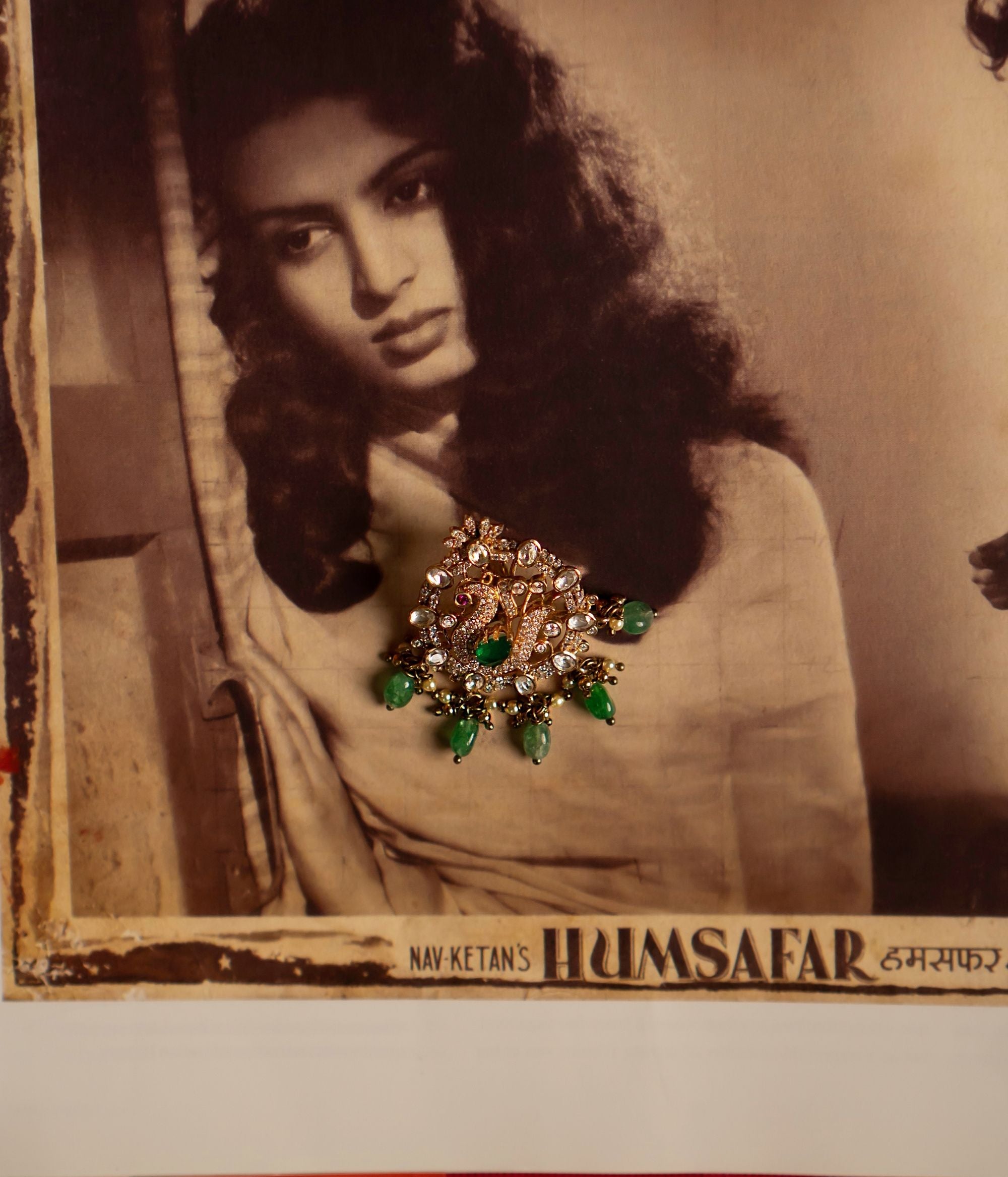 A mesmerizing gold-plated silver pendant featuring a majestic peacock at its center, intricately crafted with CZ stones and vibrant red cz stones. Encircling the peacock is a delicate arrangement of shimmering Polki stones, enhancing its regal allure. The pendant is further adorned with cascading drops of lush green strawberry quartz, adding a touch of elegance and charm. A perfect blend of tradition and craftsmanship, this pendant exudes timeless beauty.