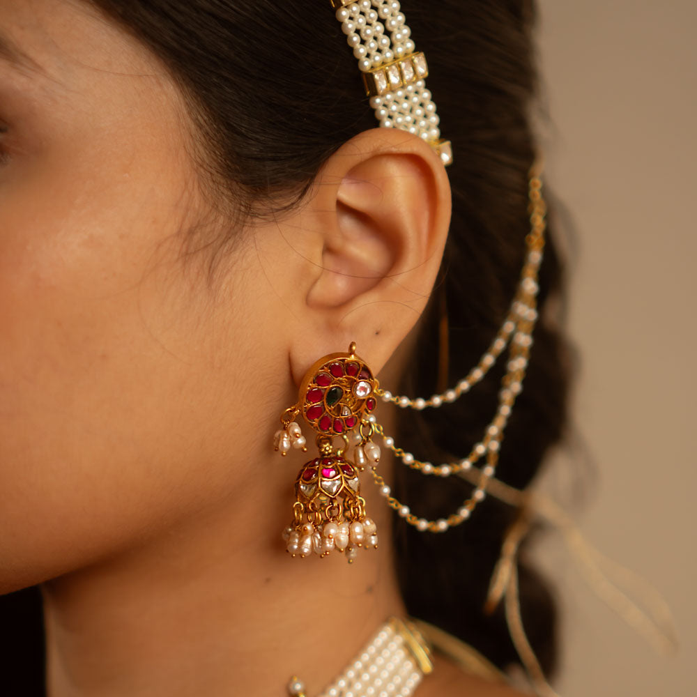 The Mogra earrings, designed in gold-plated silver and adorned with vibrant red, white, and green kundans along with delicate pearls, capture the essence of vintage elegance. A timeless jewel reminiscent of heirloom treasures.