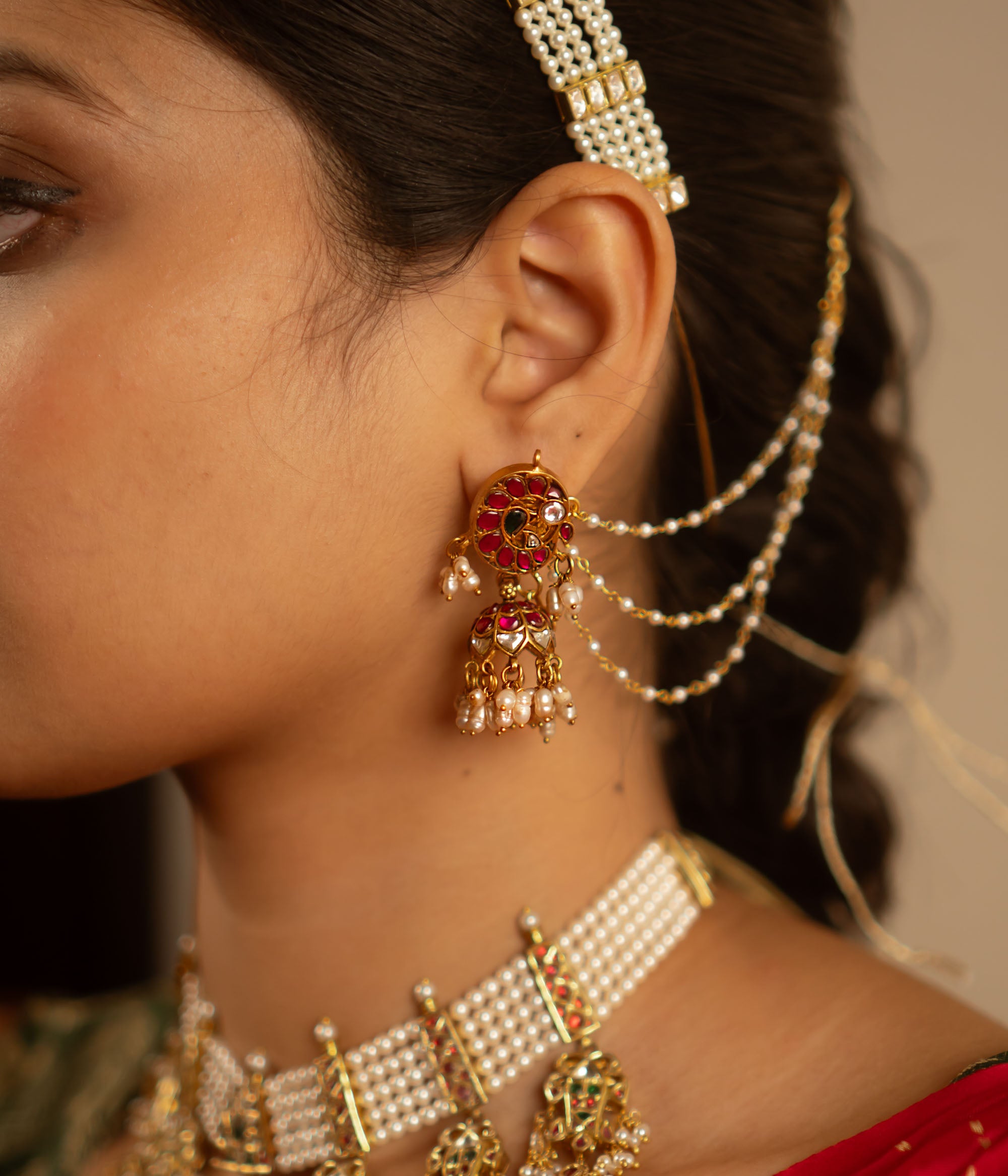 The Mogra earrings, designed in gold-plated silver and adorned with vibrant red, white, and green kundans along with delicate pearls, capture the essence of vintage elegance. A timeless jewel reminiscent of heirloom treasures.