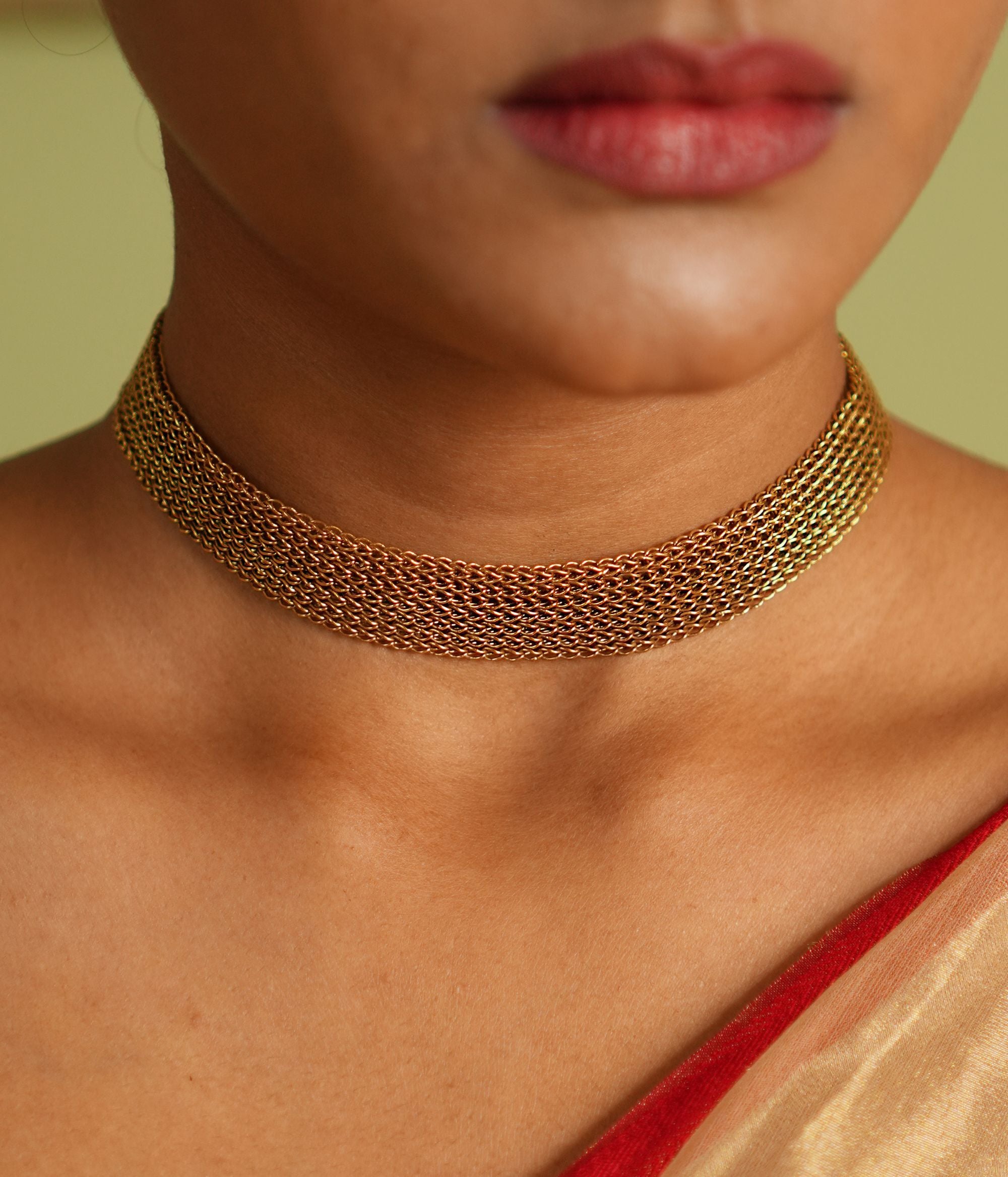 A vintage-inspired gold-plated silver mesh choker exudes an air of timeless sophistication, weaving stories of heritage and elegance.