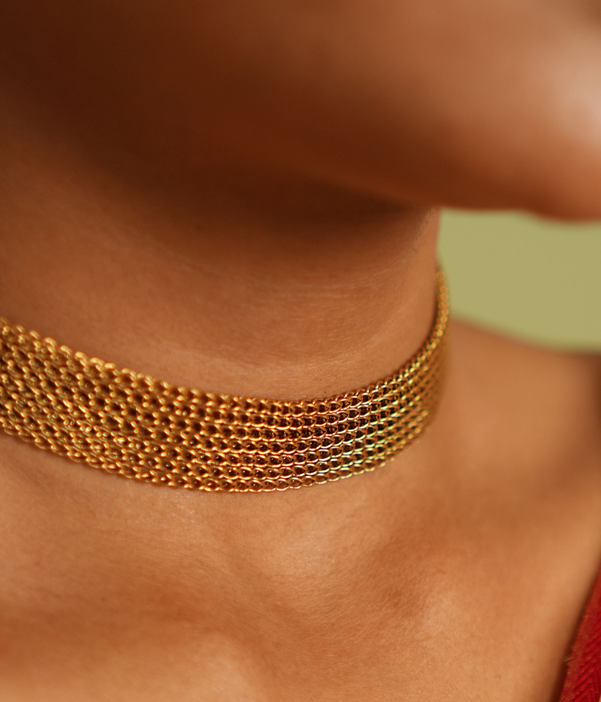 A vintage-inspired gold-plated silver mesh choker exudes an air of timeless sophistication, weaving stories of heritage and elegance.
