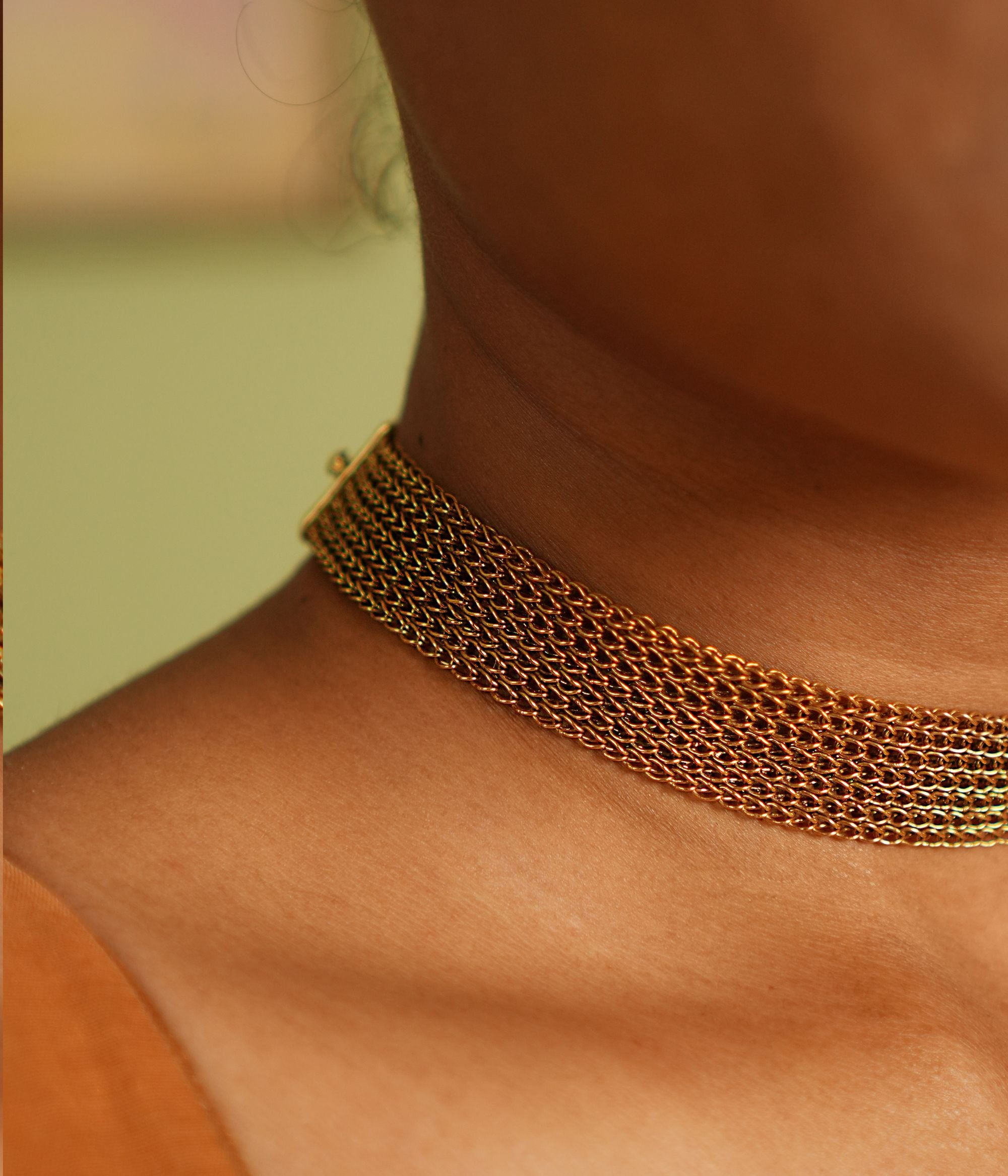 A vintage-inspired gold-plated silver mesh choker exudes an air of timeless sophistication, weaving stories of heritage and elegance.