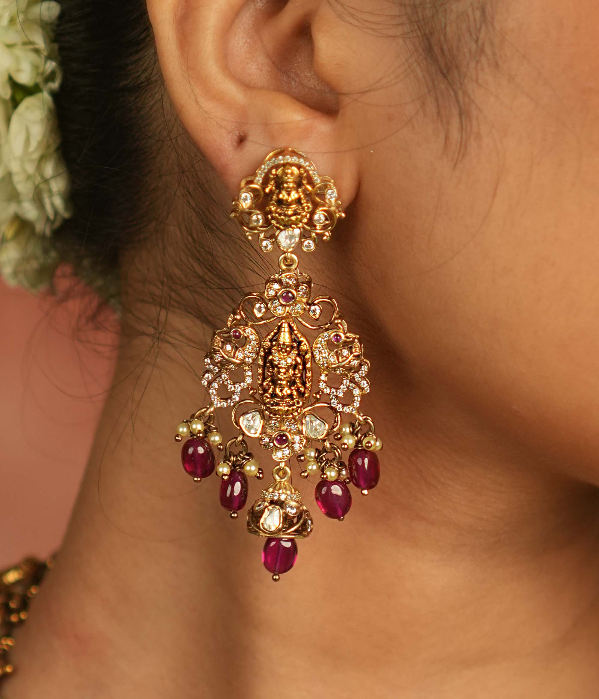 Celestial whispers reborn! These gold-plated Chandbali earrings showcase radiant red spinel stones, shimmering polki and CZ stones, adorned with green beads and delicate pearls. A timeless tribute to spiritual heritage and elegant craftsmanship.
