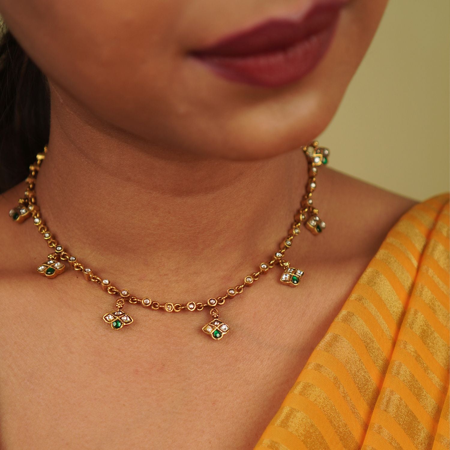 Mythri Necklace: A harmonious design of symmetrical units, this gold-plated silver piece showcases red and white Kundan stones, blending traditional craftsmanship with modern elegance, embodying Indian grace.