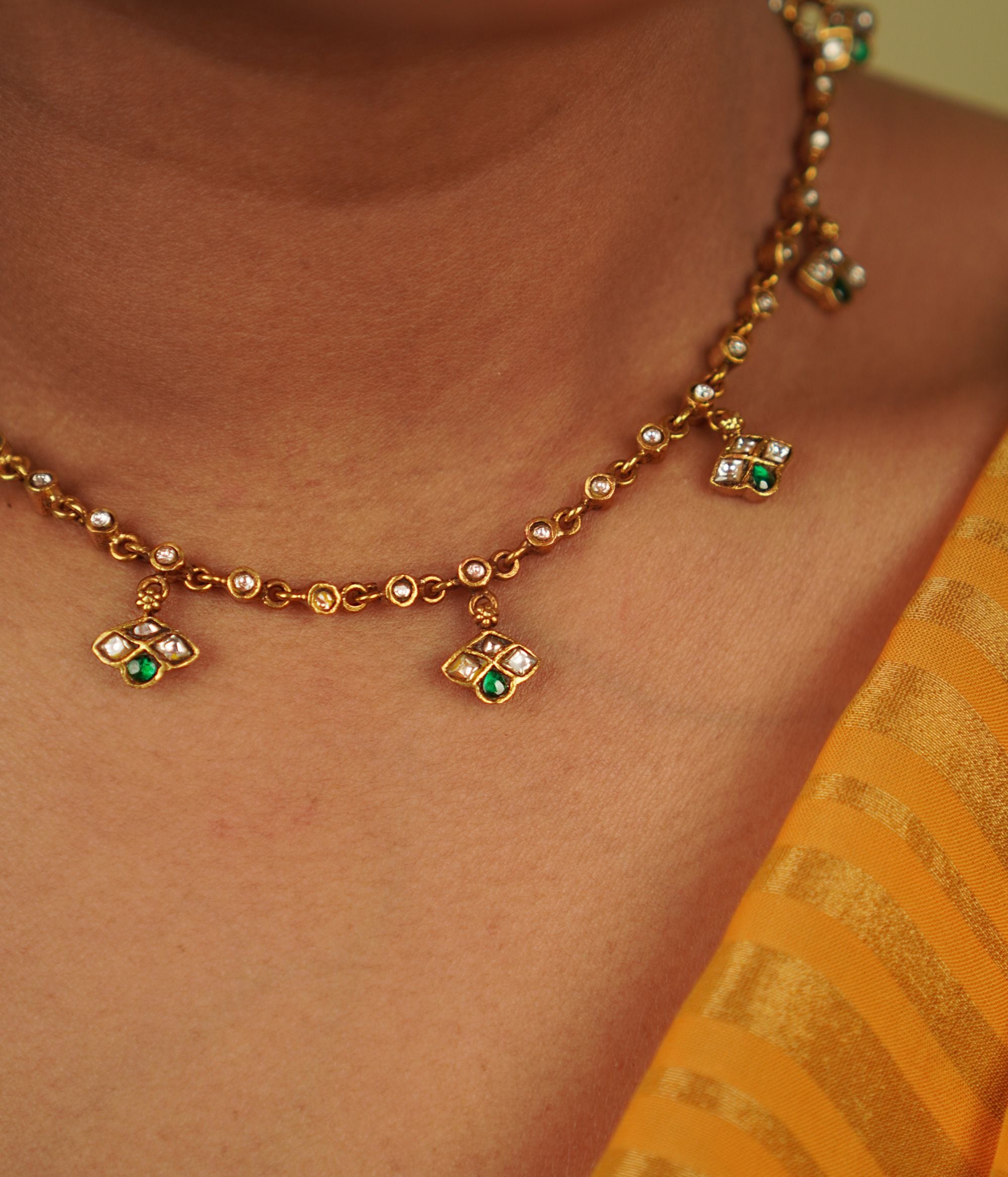 Mythri Necklace: A harmonious design of symmetrical units, this gold-plated silver piece showcases red and white Kundan stones, blending traditional craftsmanship with modern elegance, embodying Indian grace.