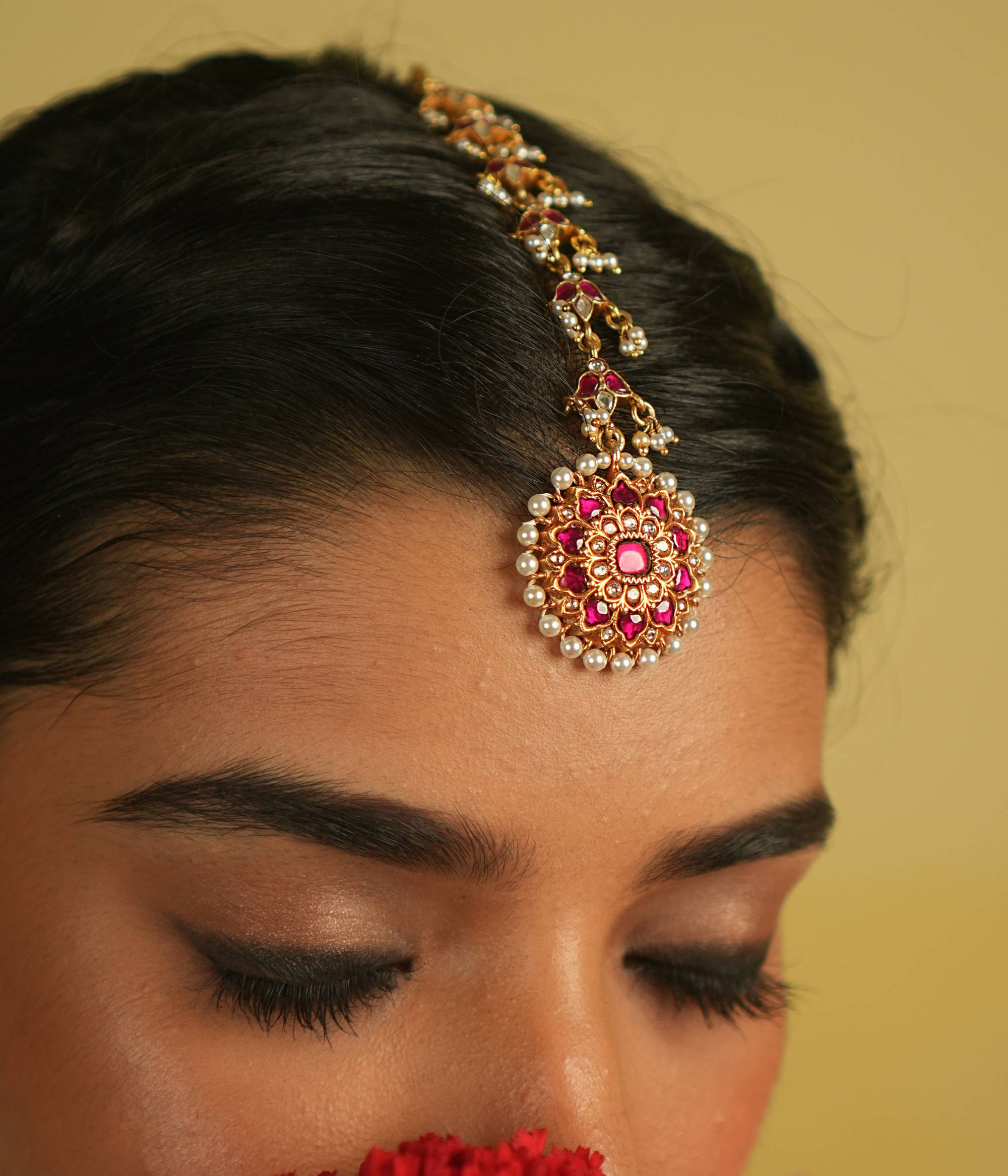 Embrace timeless tradition with our exquisite Kundan Tikka, adorned with radiant red and white Kundan stones, complemented by lustrous pearls. Its flawless craftsmanship exudes elegance, making it a perfect piece for any occasion.