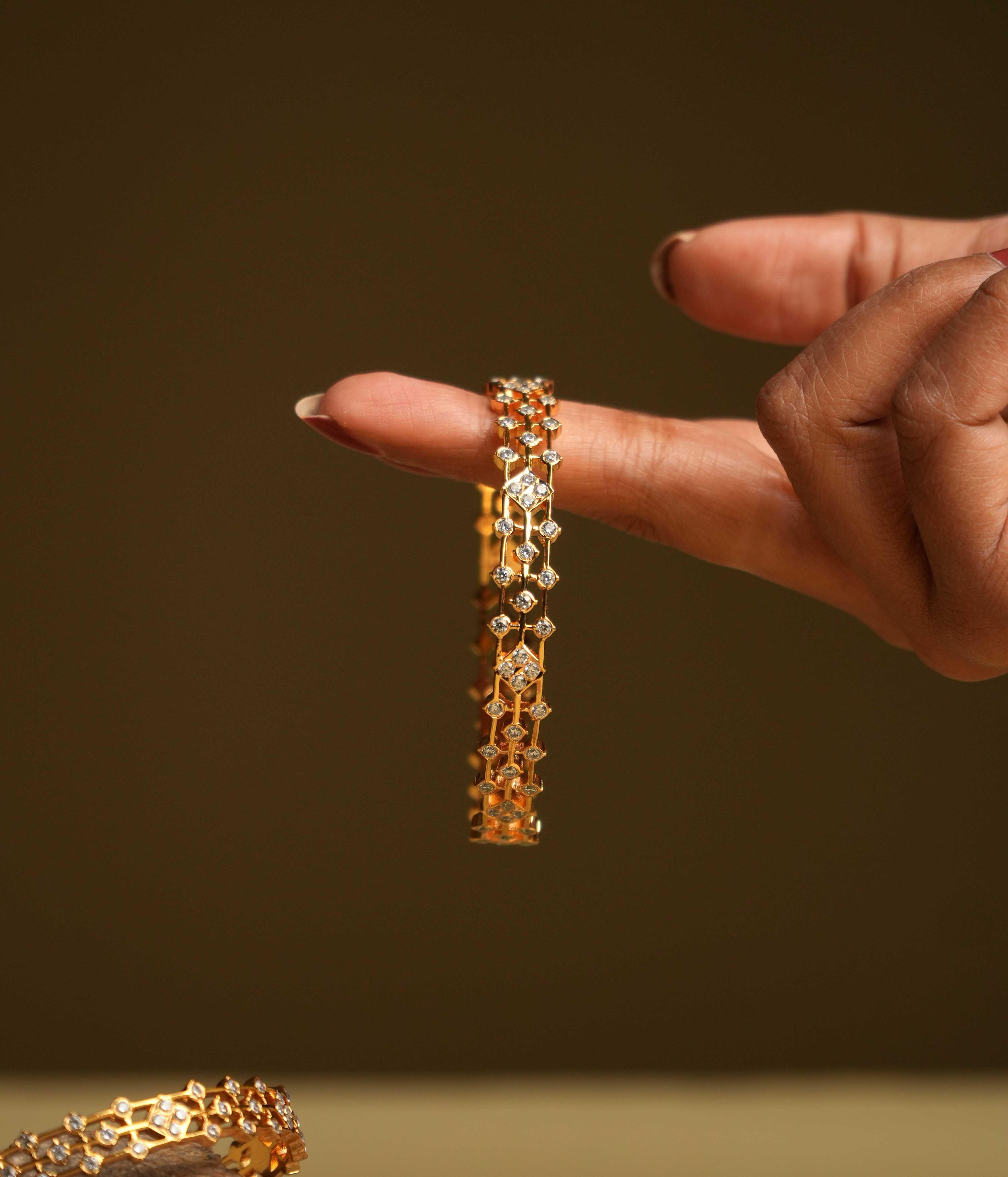 A triple-lined 92.5 sterling silver bangle with an insert type closure, featuring clusters of moissanite intricately set in geometric florals, inspired by traditional diamond setting, exudes regal elegance and modern sophistication.