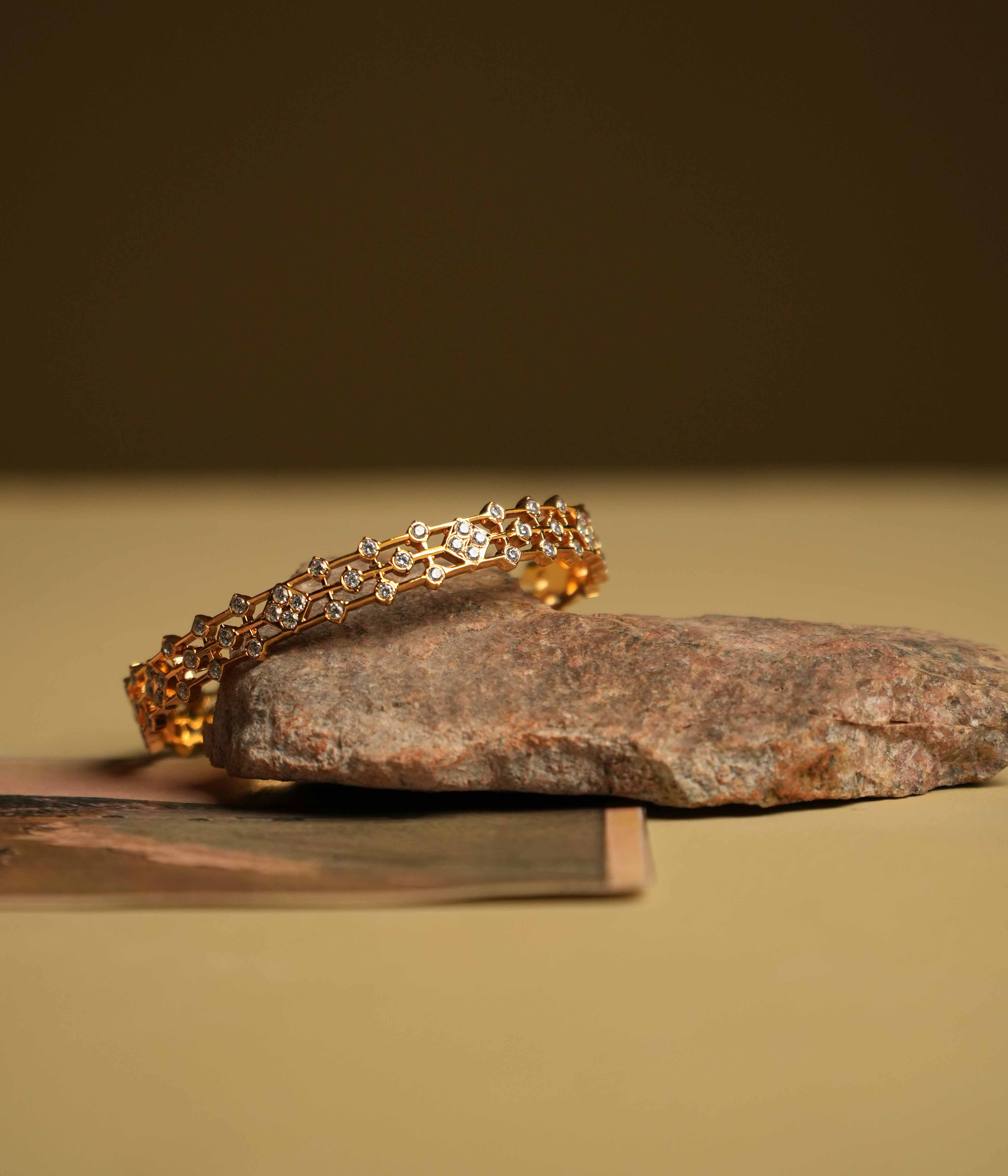 A triple-lined 92.5 sterling silver bangle with an insert type closure, featuring clusters of moissanite intricately set in geometric florals, inspired by traditional diamond setting, exudes regal elegance and modern sophistication.