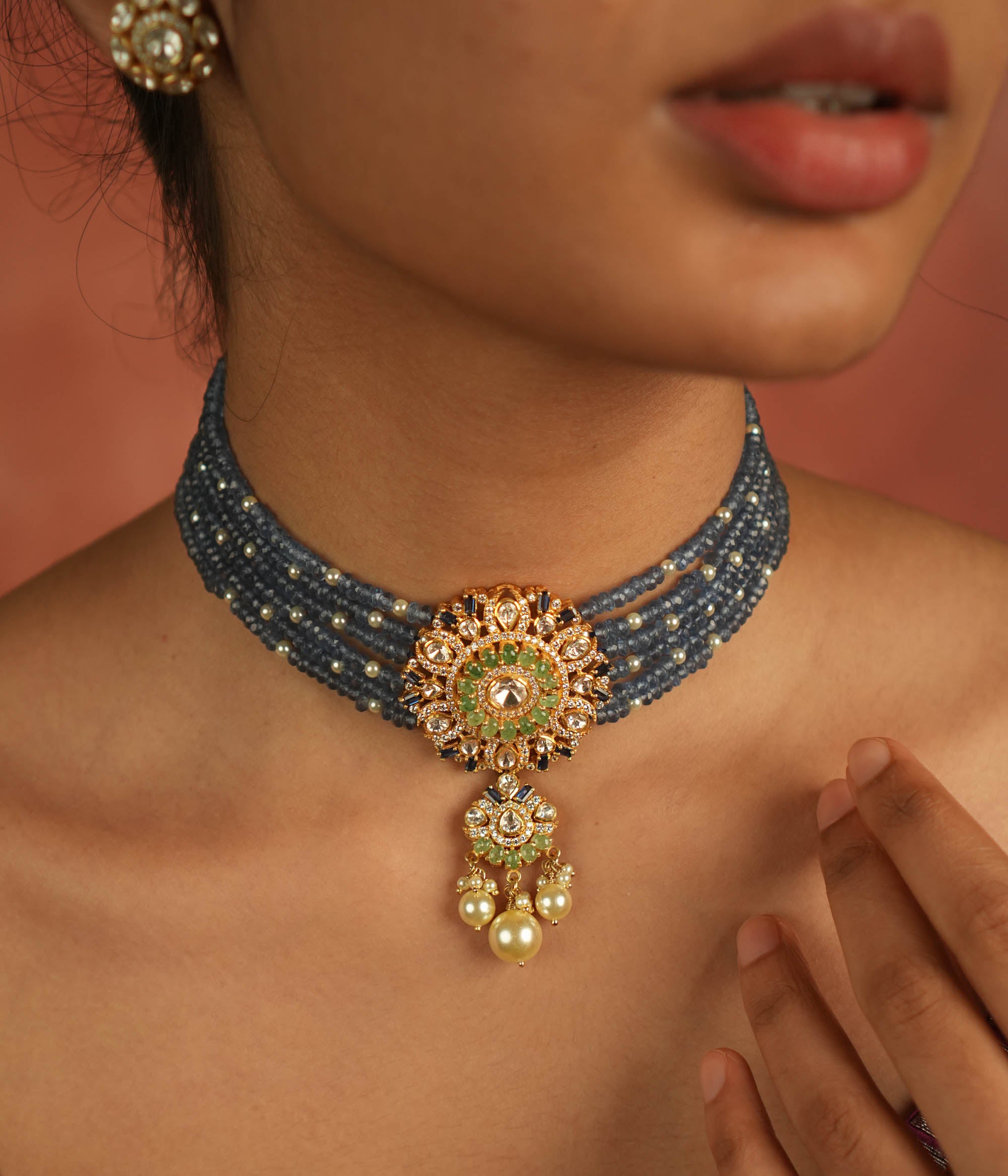 Regal elegance reimagined! This layered beaded choker, adorned with a round pendant of polki, CZ stones, and pearls, echoes timeless grandeur.