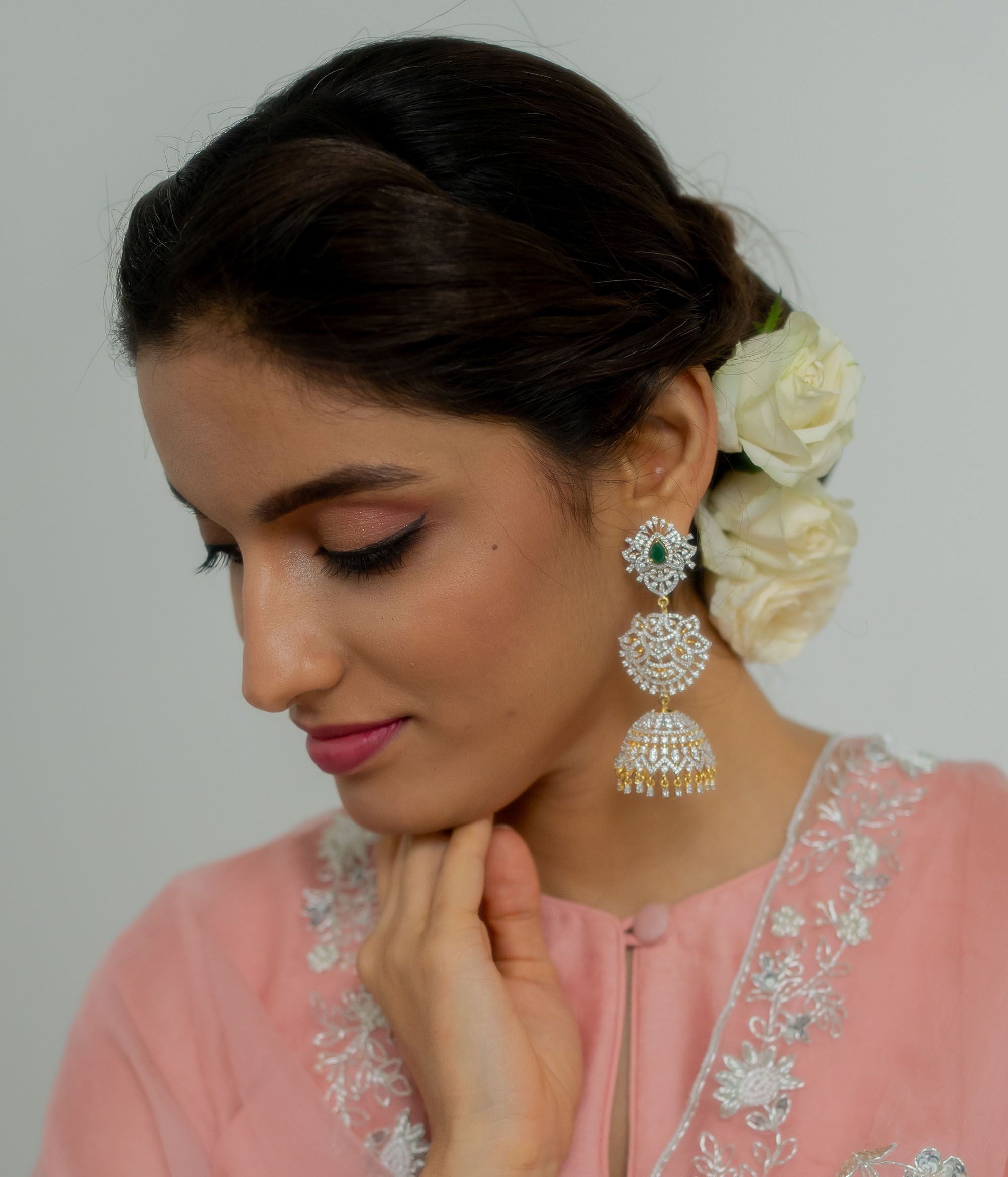 The Nakshatra Stone Jhumka features a mesmerizing green doublet stone and dazzling CZ accents, exuding timeless elegance with a radiant charm.