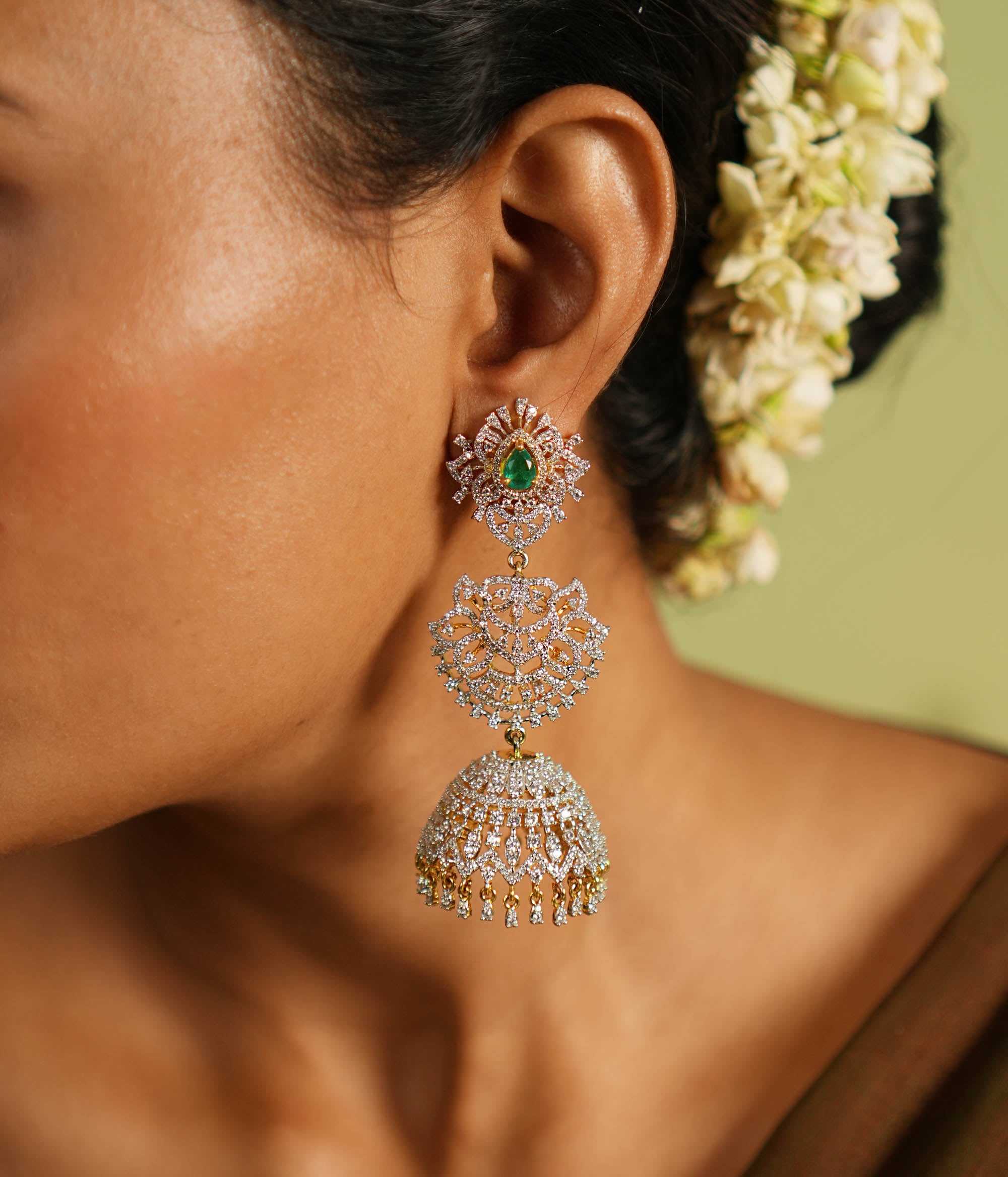 The Nakshatra Stone Jhumka features a mesmerizing green doublet stone and dazzling CZ accents, exuding timeless elegance with a radiant charm.