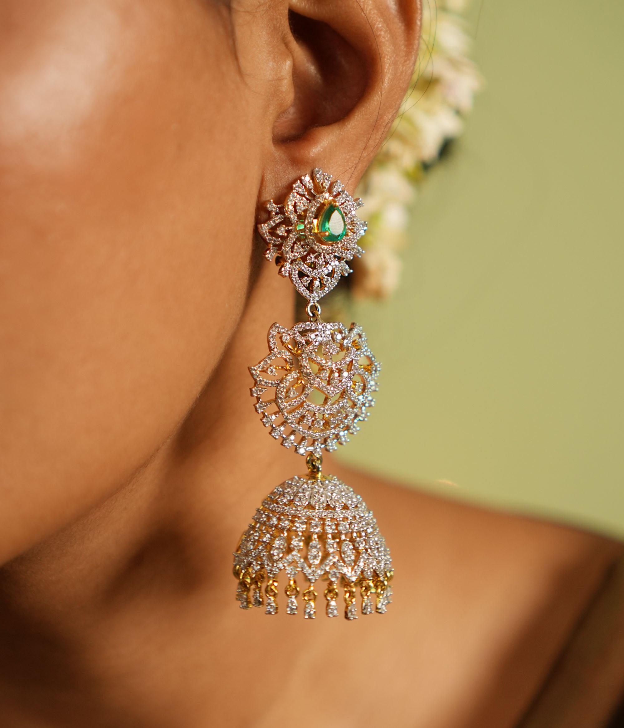 The Nakshatra Stone Jhumka features a mesmerizing green doublet stone and dazzling CZ accents, exuding timeless elegance with a radiant charm.