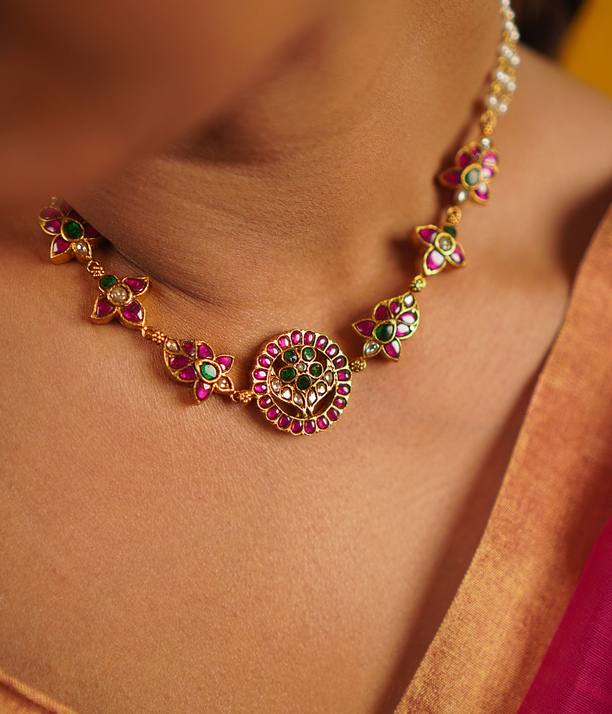 The Narcissus necklace, handcrafted in gold-plated silver, is adorned with vibrant red, white, and green kundans, complemented by delicate freshwater pearls. This vintage-inspired piece exudes a refined elegance, celebrating tradition with a touch of timeless charm.