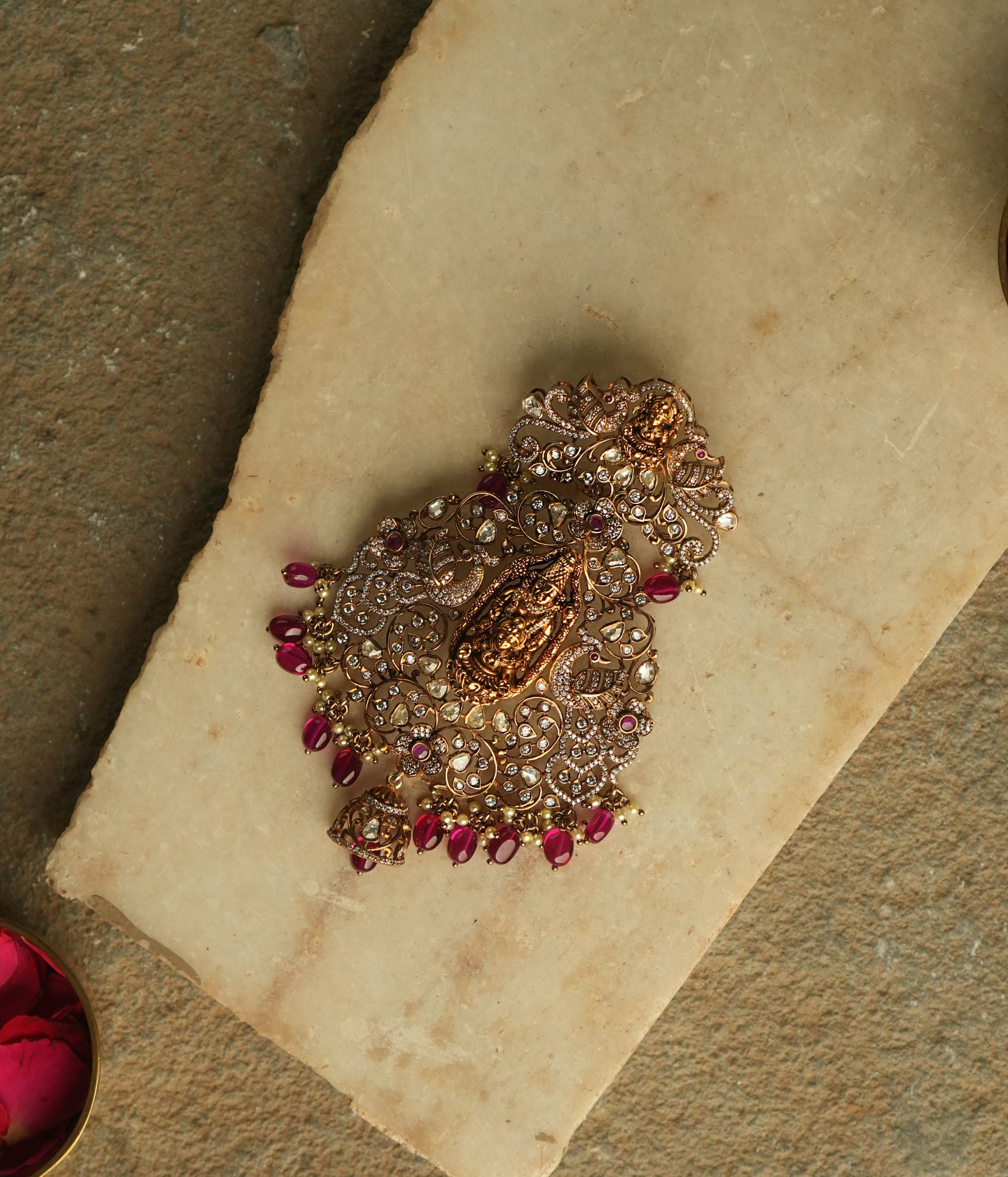 This exquisite pendant showcases the divine goddess Lakshmi, gracefully encircled by radiant Polki and Moissanite stones, symbolizing prosperity and elegance.